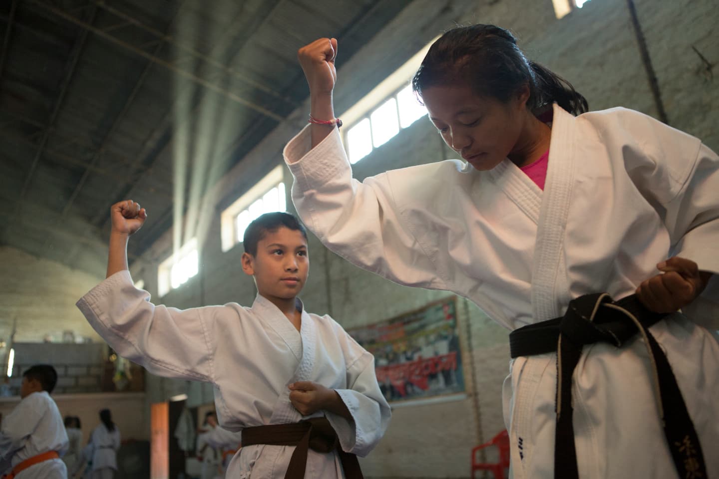 A young black belt leads Rai through a kata at the karate dojo where she trains daily in Kathmandu.
