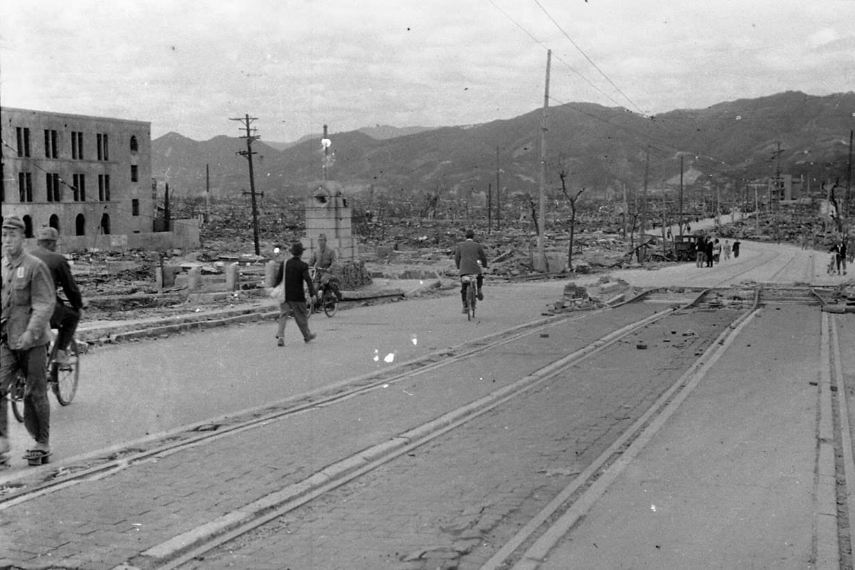 People walk past destroyed buildings at Aioi Bridge.