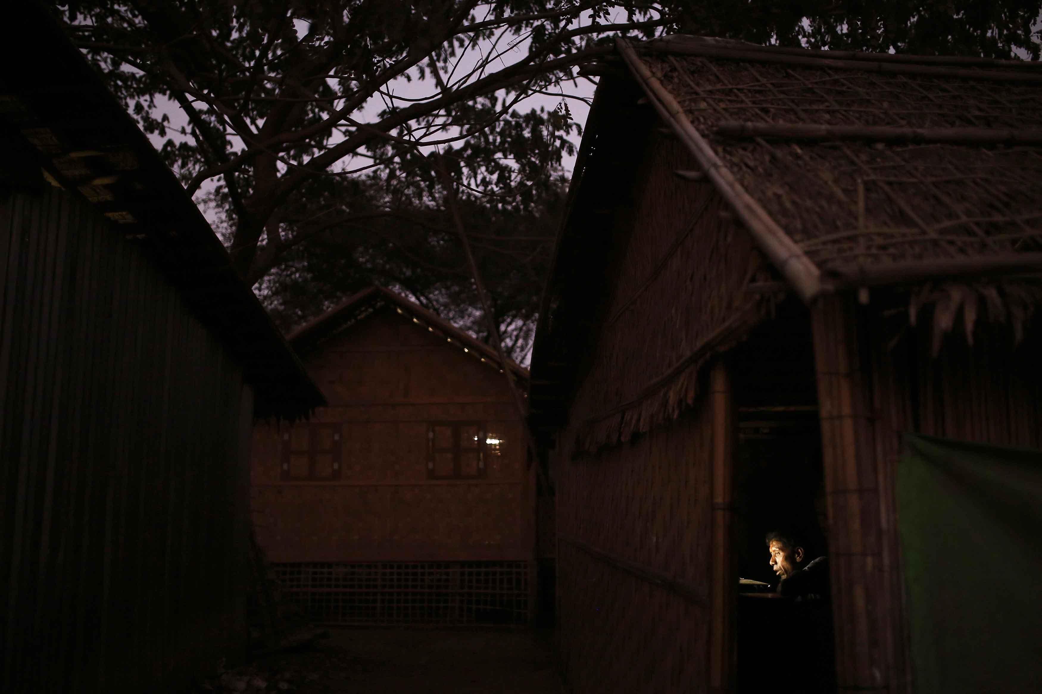 A man speaks at a computer in an internet hut in Thae Chaung village.