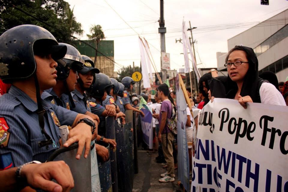 Police prevent marchers from nearing the pope's motorcade in Manila on January 15, 2015.
