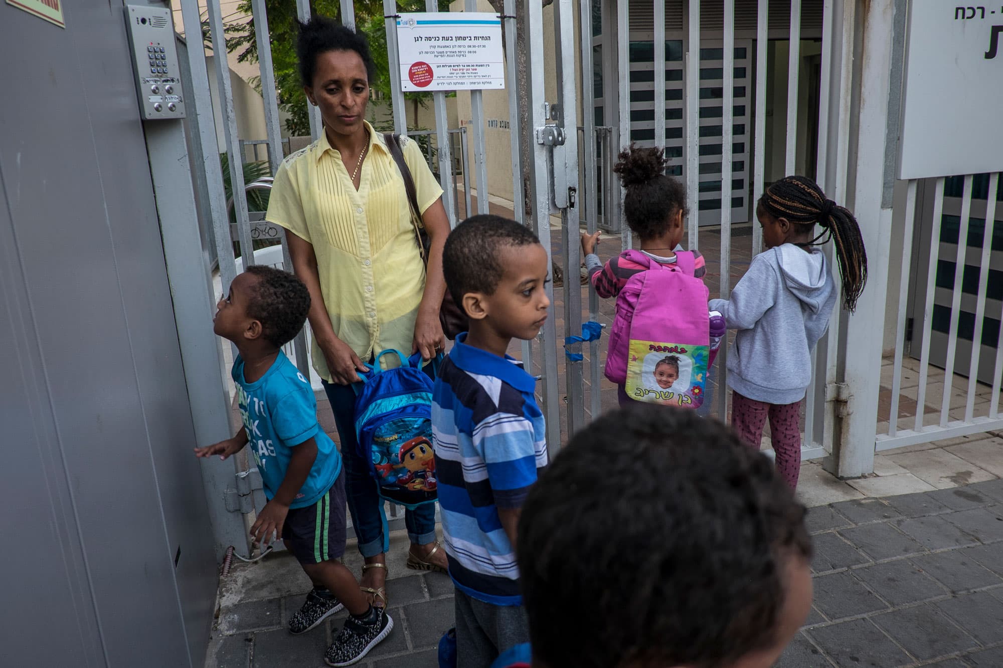 Brkitay Gebru escorts her son Tarik, 4, to kindergarten. Each morning, she wakes early since she must prepare and take her sons to school before heading to her work as a janitor — a one-hour bus ride.
