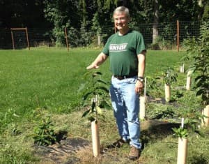 William A. Powell standing next to one of the most blight-resistant trees from the “Darling” line of transgenic American chestnut trees.