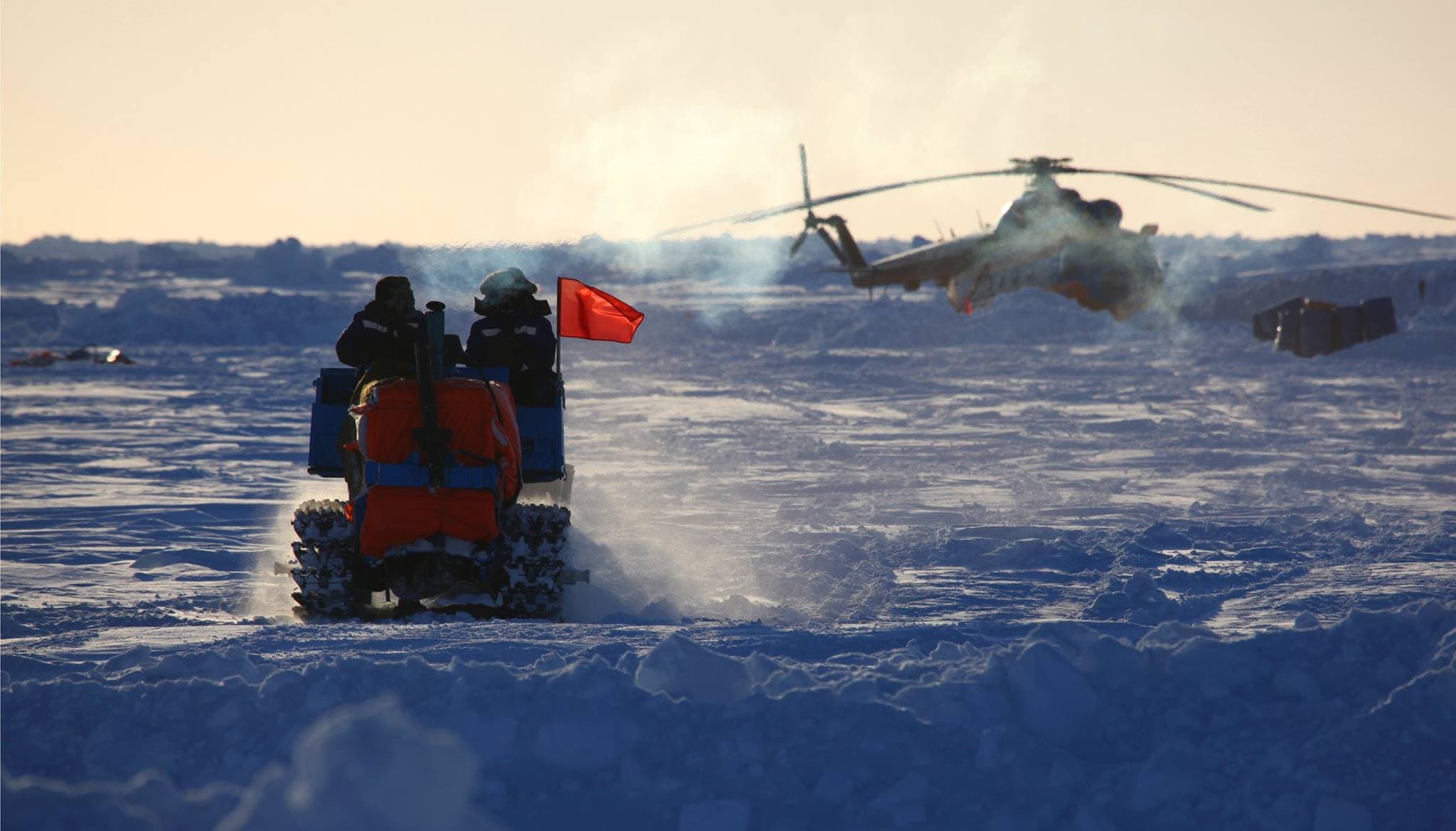 Workers watch a helicopter