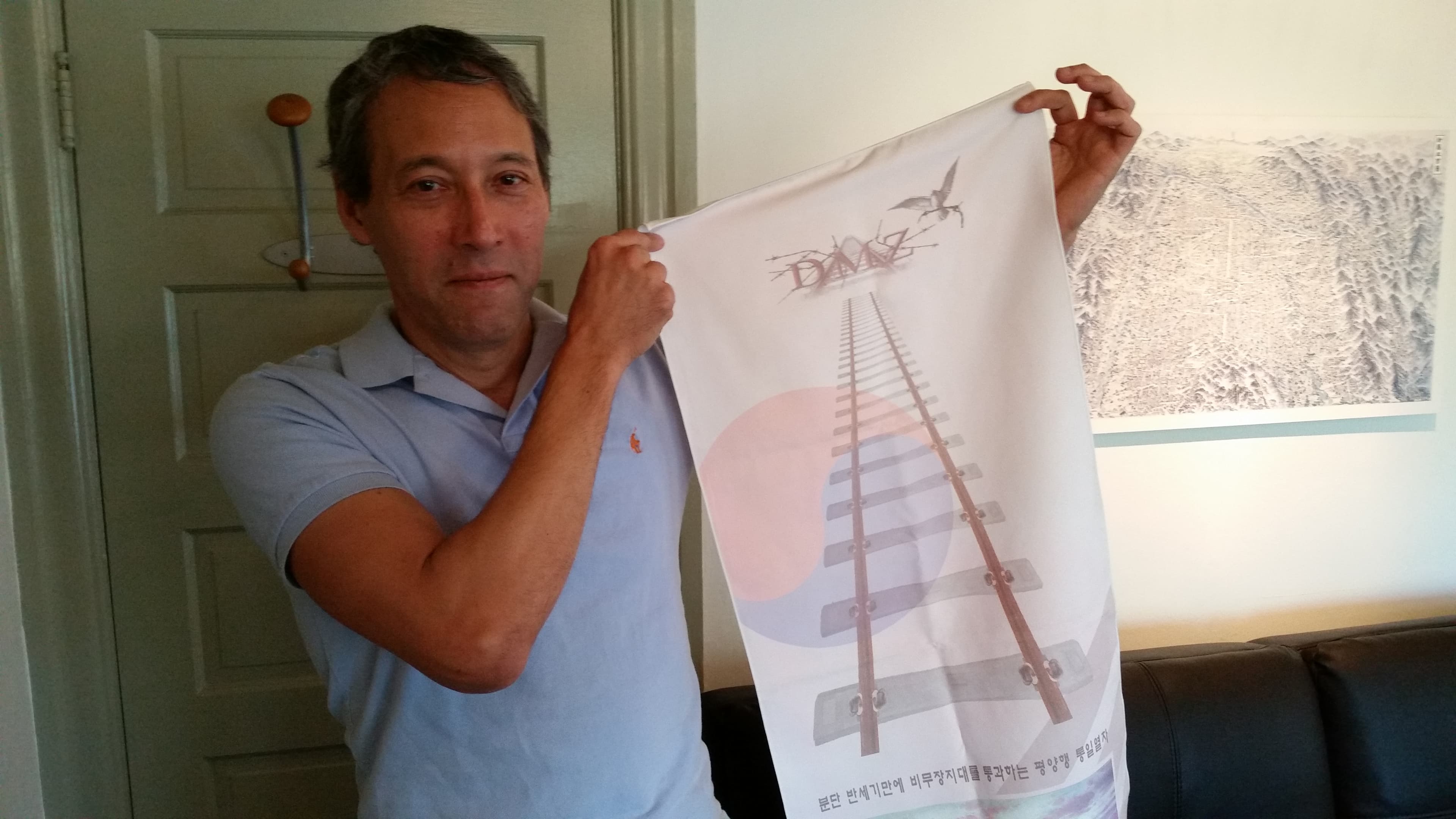 David Kang holds a memorial banner from his visit to Kaesong, North Korea.