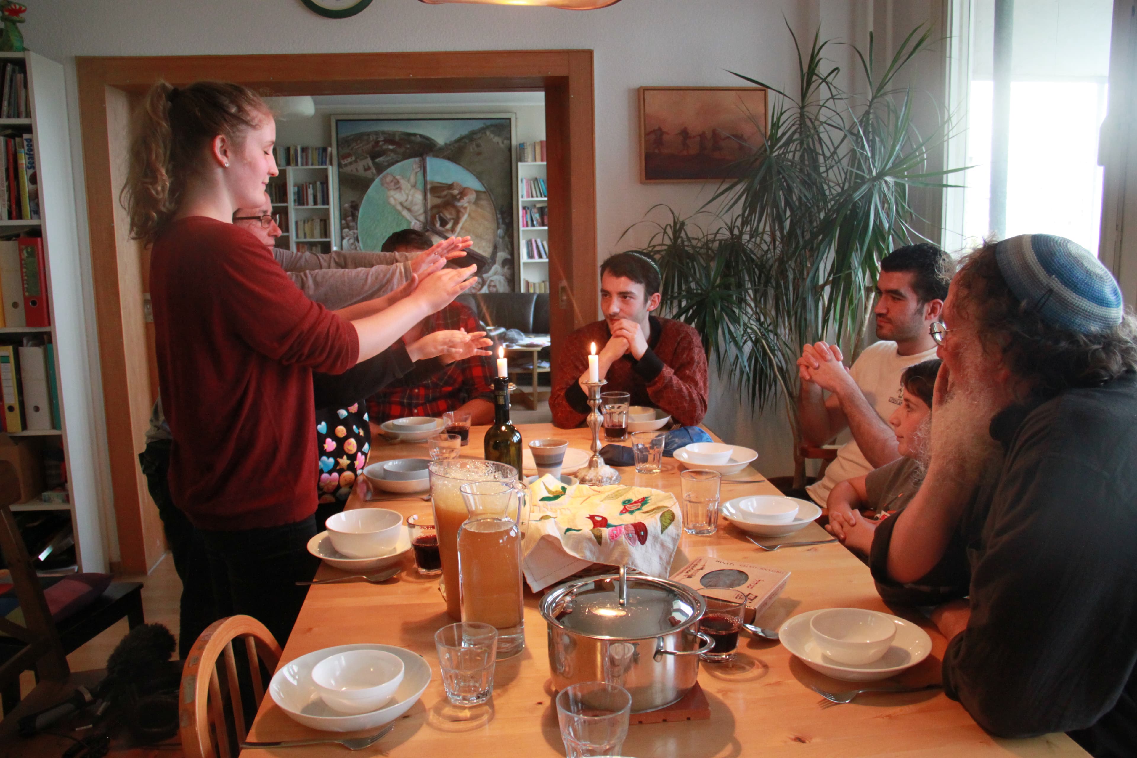 The Jellinek family lights the Sabbath candles for Friday night dinner. Chaim Jellinek says he thinks the only good way to integrate refugees is to welcome them.