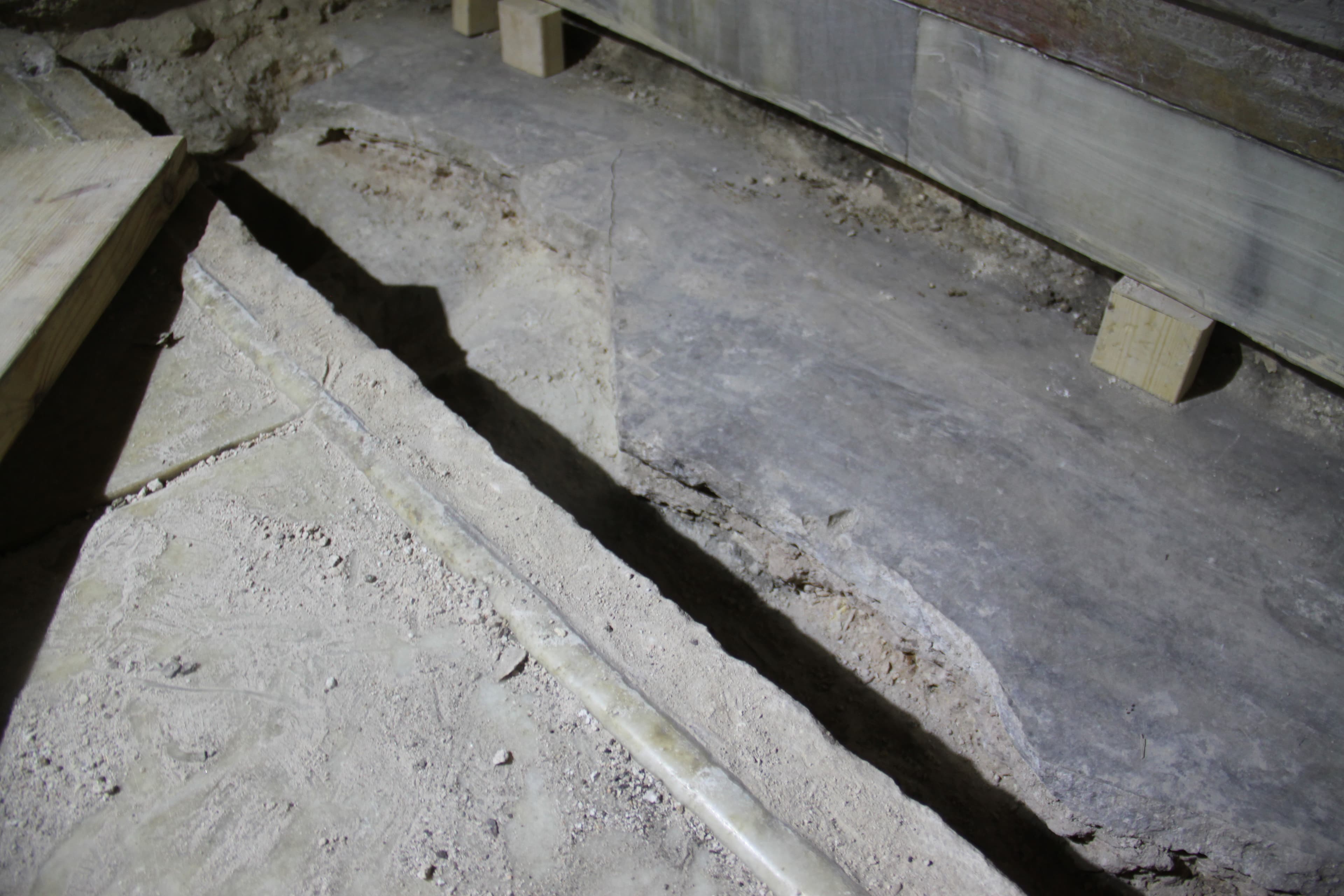 The marble lid (on the left) was pulled off, revealing a partly broken gray slab of marble. Under that is the debris-covered limestone layer where Jesus; body was said to have been placed after he was crucified.