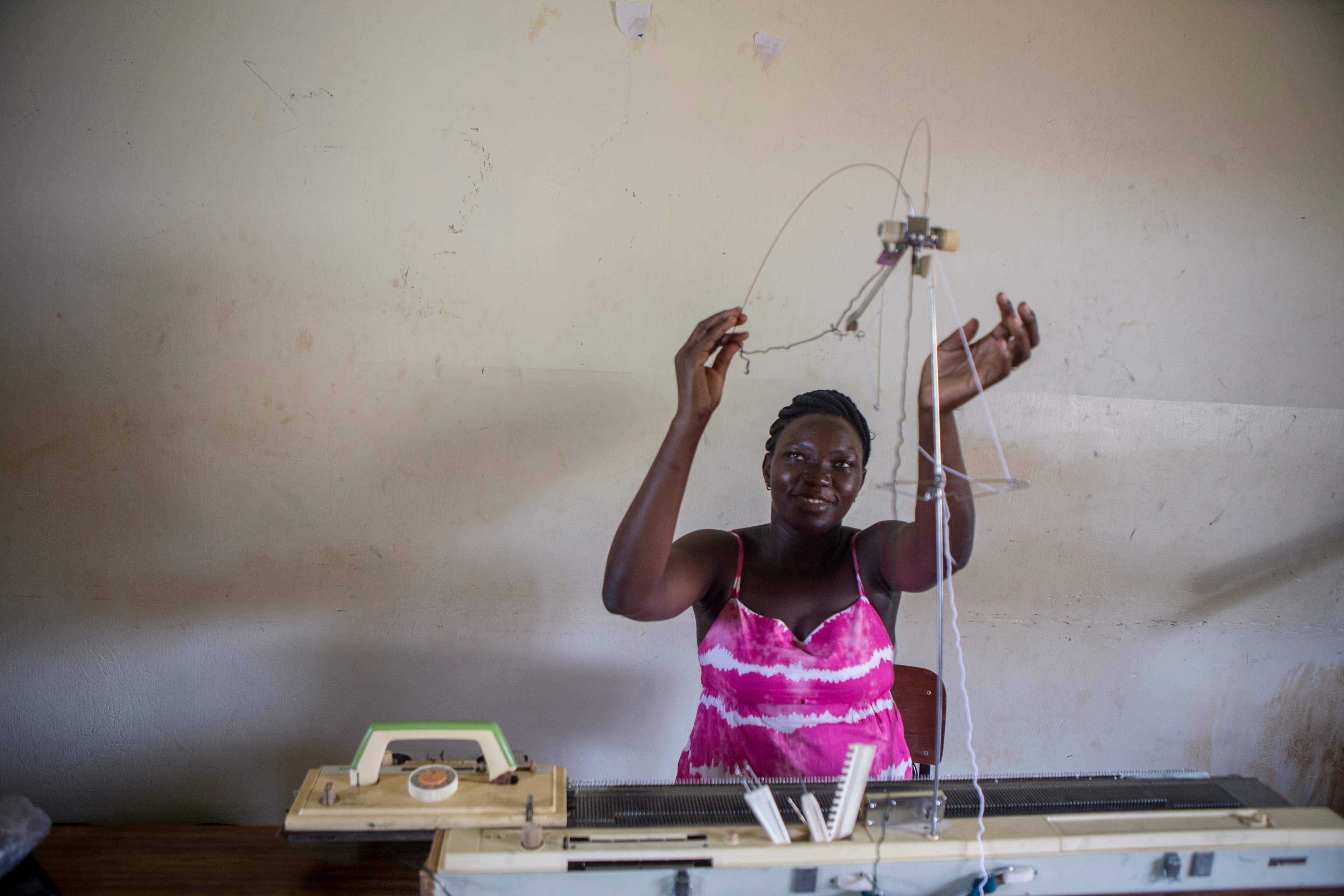 A young woman at a sewing machine.
