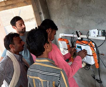 SHRI's water ATM system. Anoop Jain, SHRI's founder, is in the back.