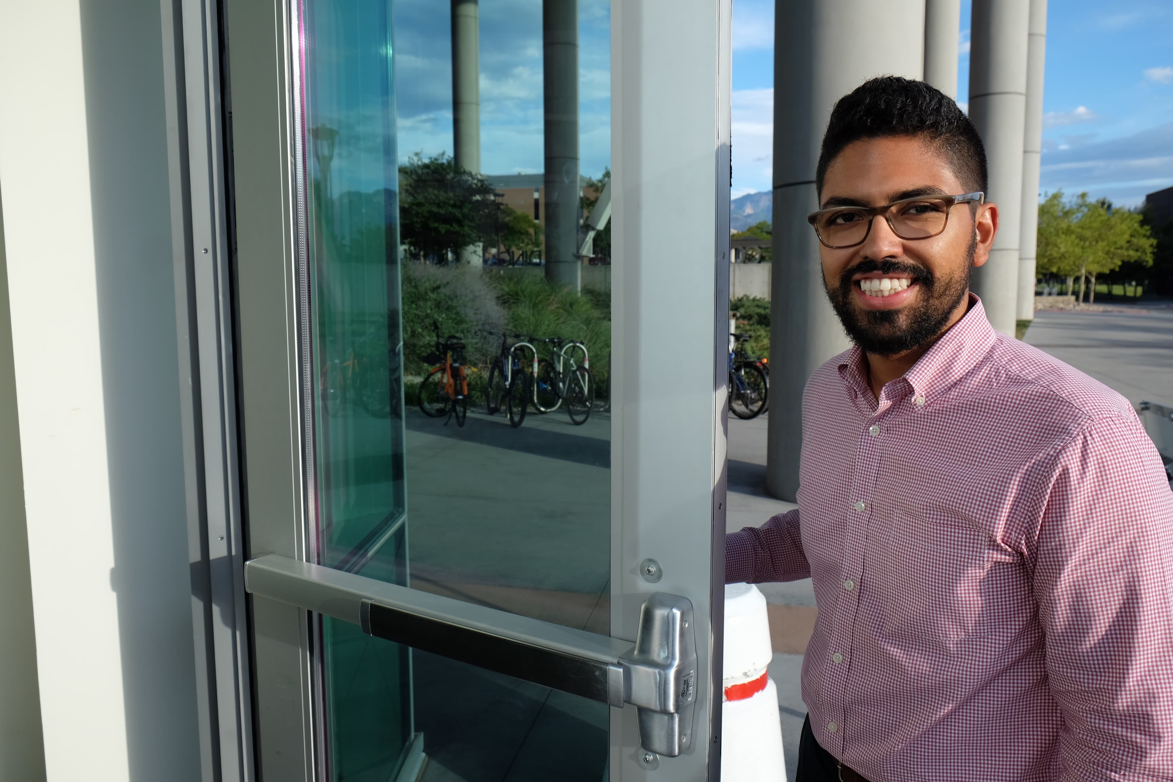 Smiling man holding door open