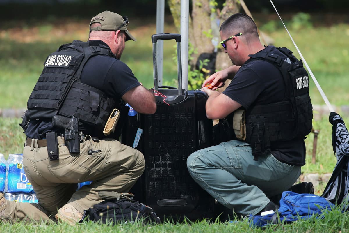 Bomb squad officers inspect a piece of unclaimed luggage on the first day of the DNC.