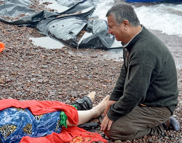 An Iraqi man mourns his wife on the beach on Lesbos on October 15, 2015.