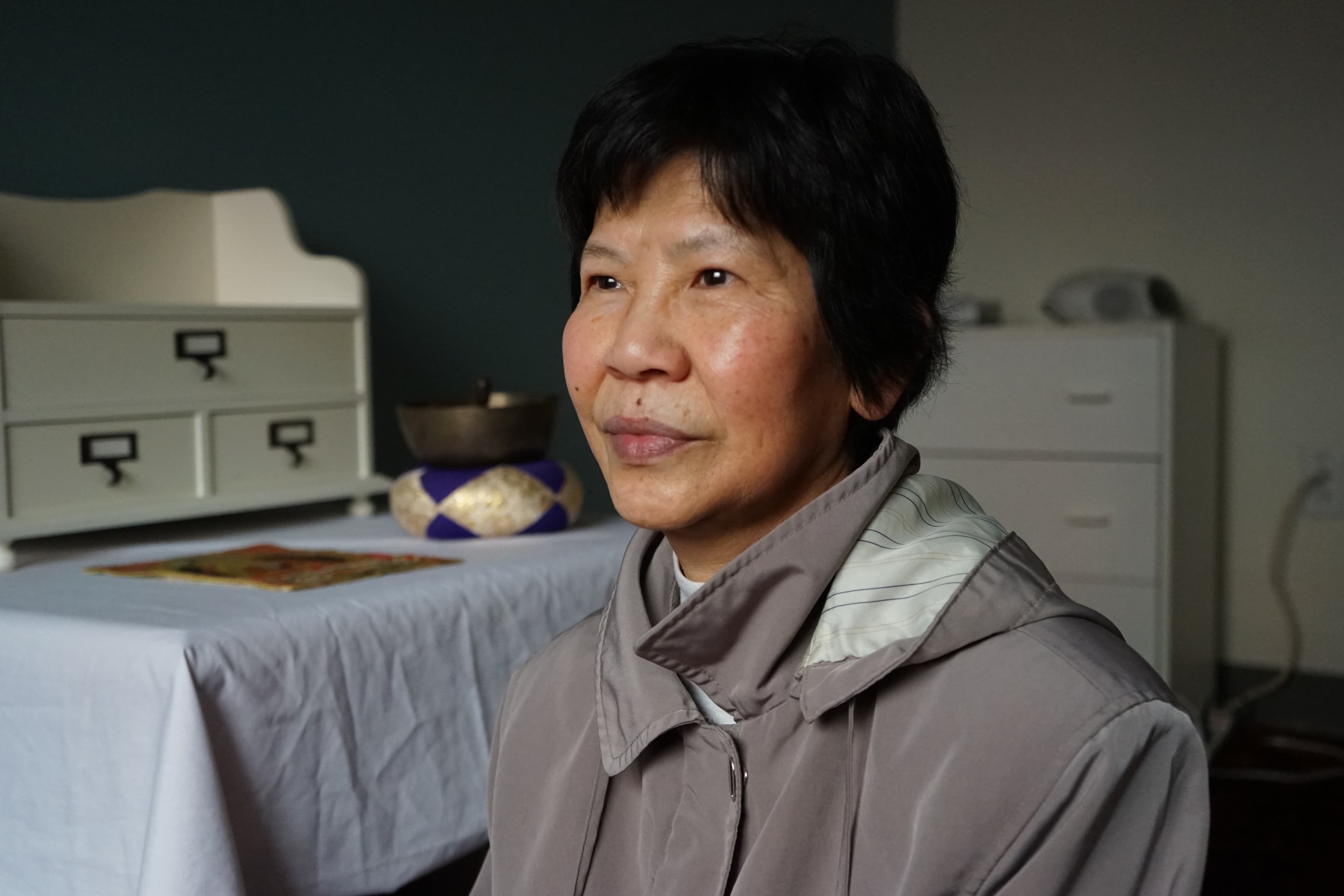 Bonnie Chan, age 64, is a survivor of Cambodia's Khmer Rouge genocide. She sits on the floor of the Metta Health Center's meditation lounge. She meditates here to treat her insomnia.