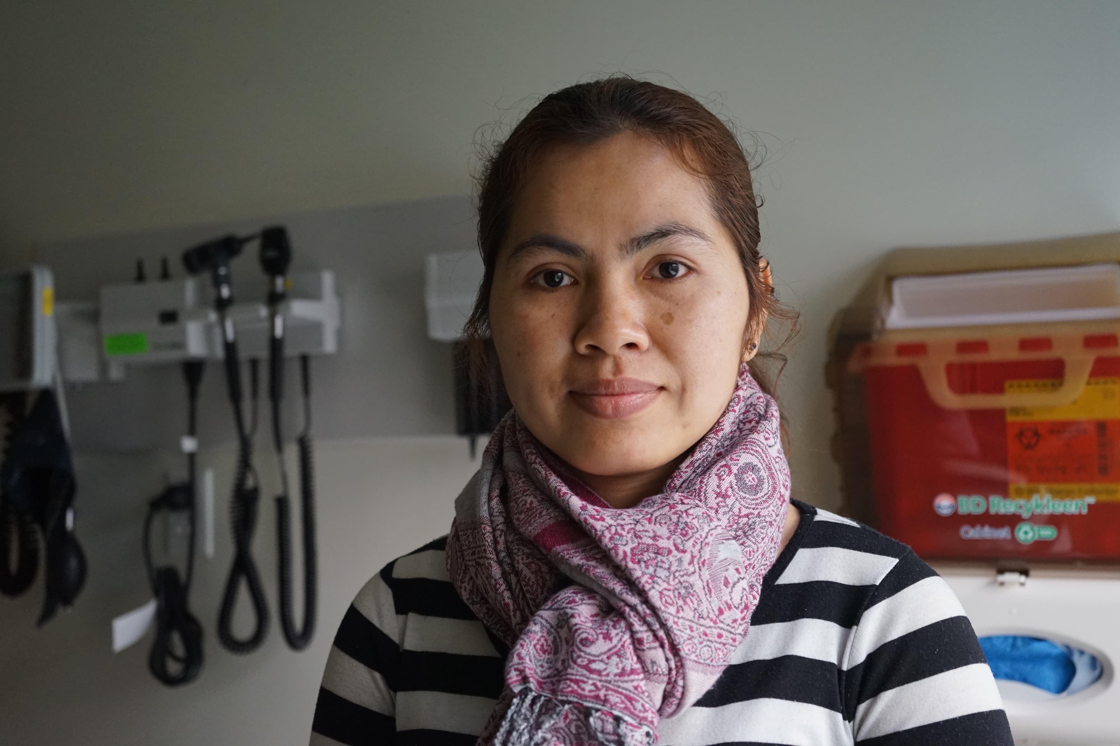 Socheat Chan refuses to take Tylenol or Advil for headaches – she opts instead for a traditional treatment called coining.  Pictured in the background are the types of medical devices that some Cambodian refugees would mistake for torture devices used on