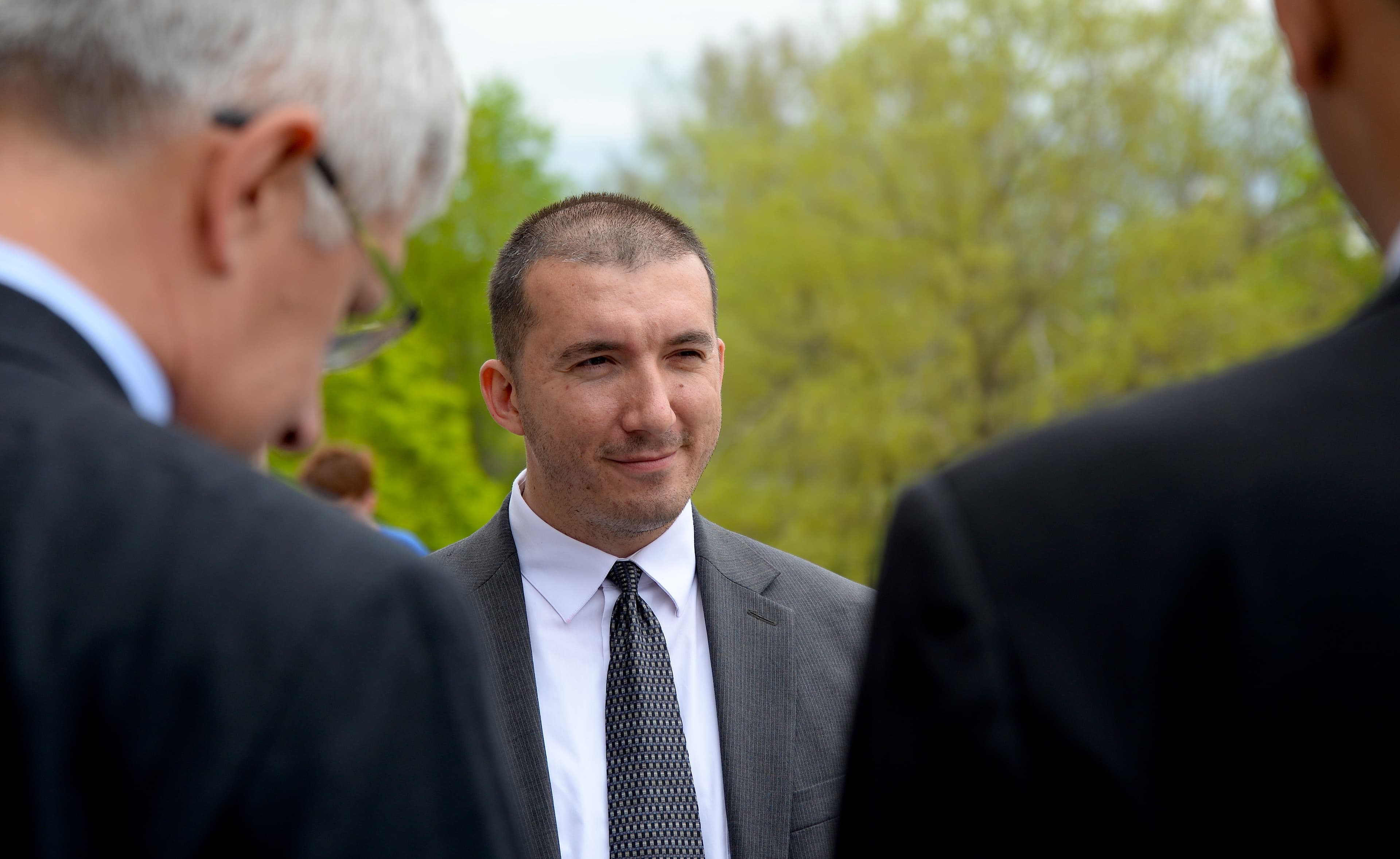 Man standing between two other men