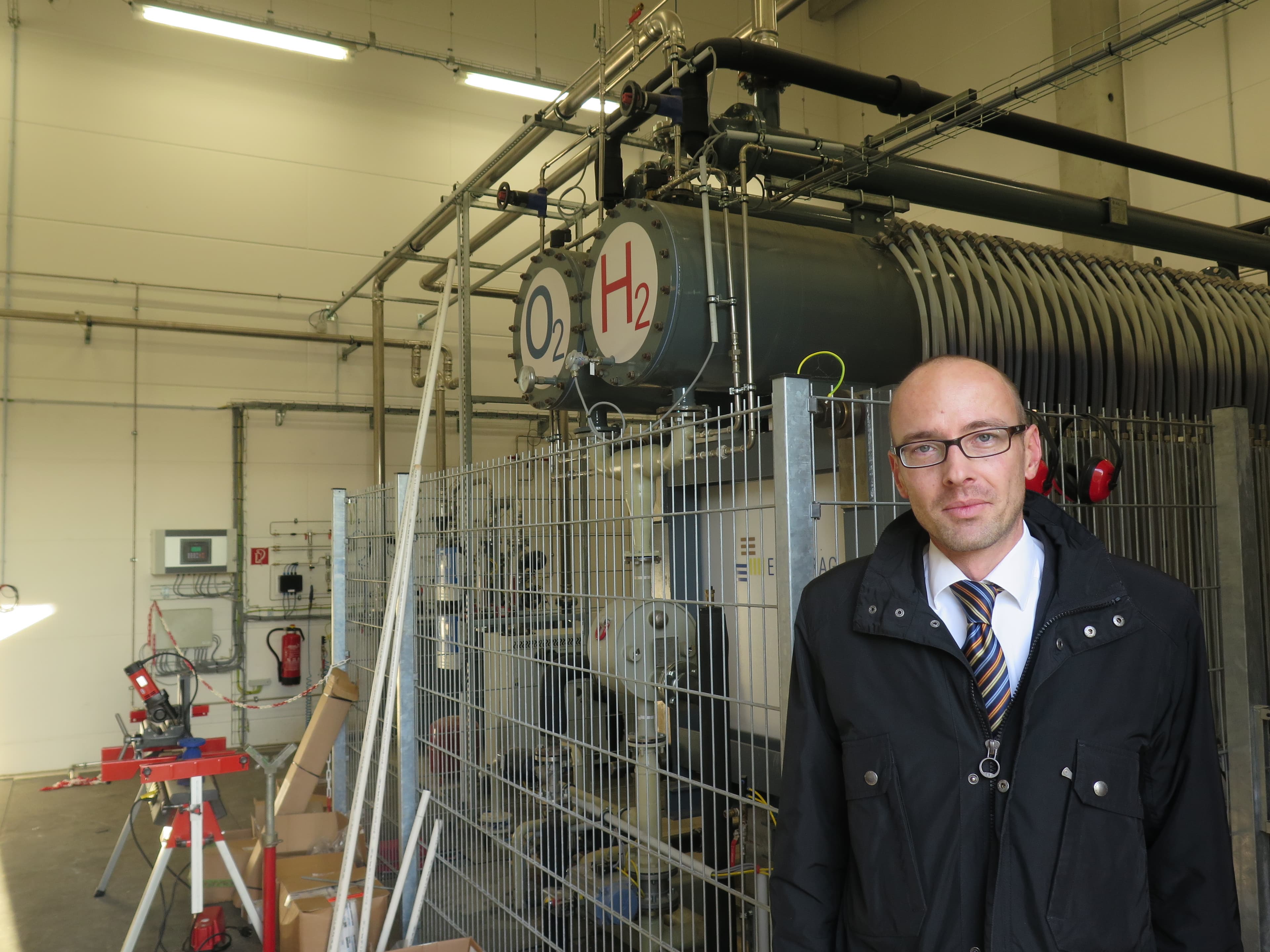Enertrag's Robert During stands in front of his company's wind-powered electrolyser in Prenzlau, Germany. Electrolyzers use electricity to split water into hydrogen and oxygen. On this site, the oxygen is released into the air and the hydrogen is used as