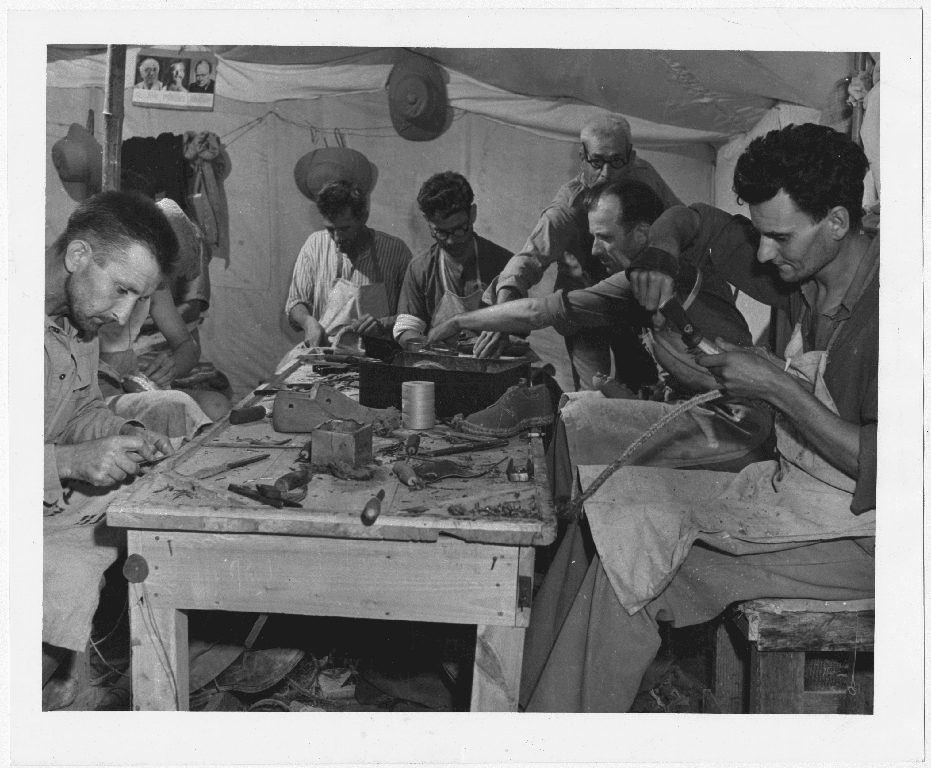 Men work around a table in a tent