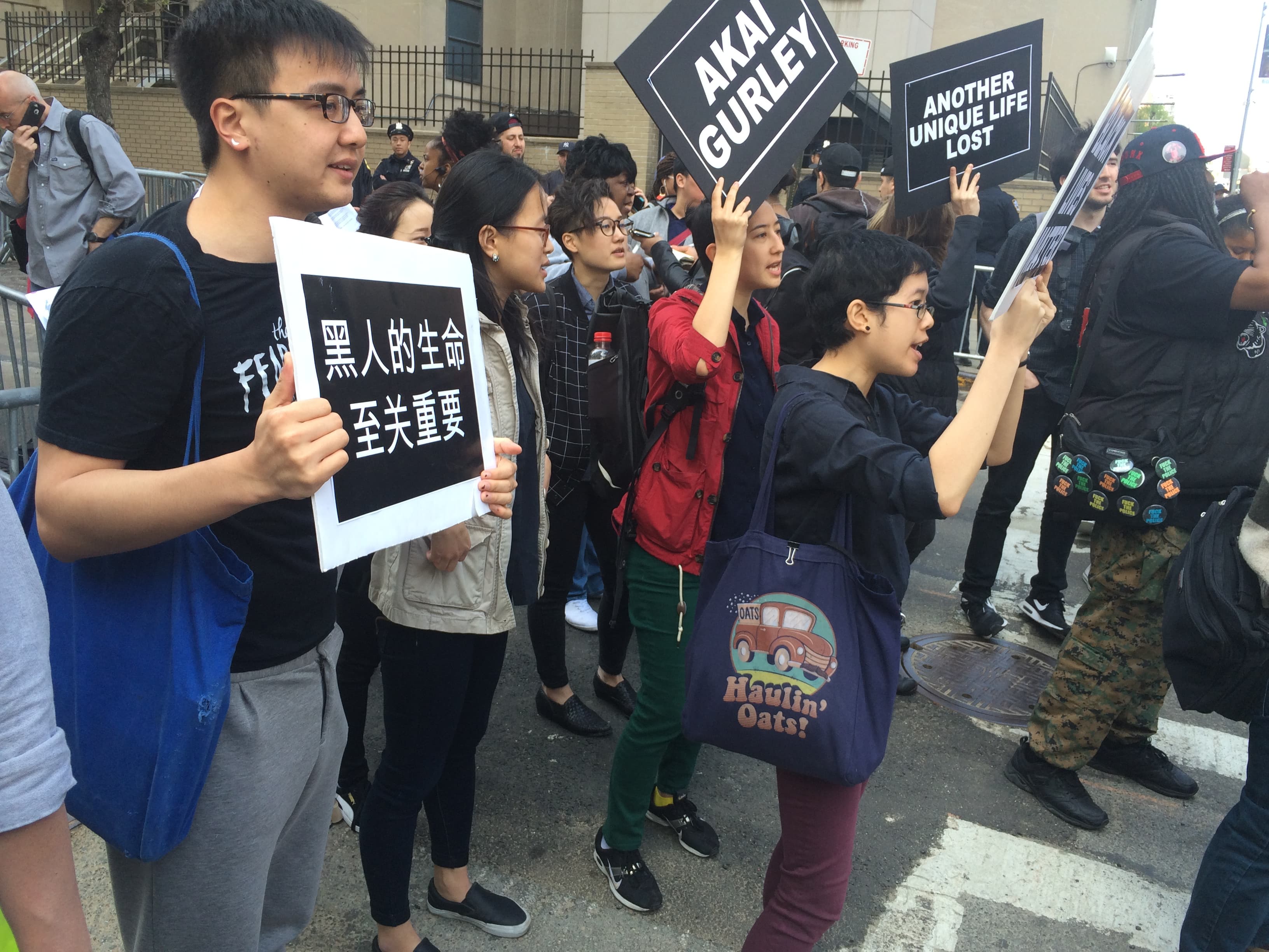 Demonstrators at the courthouse, mostly Asian American, one with a sign in Chinese
