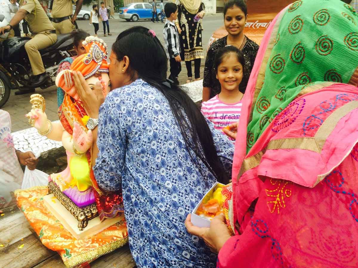 A woman kisses the Hindu God Ganesha.