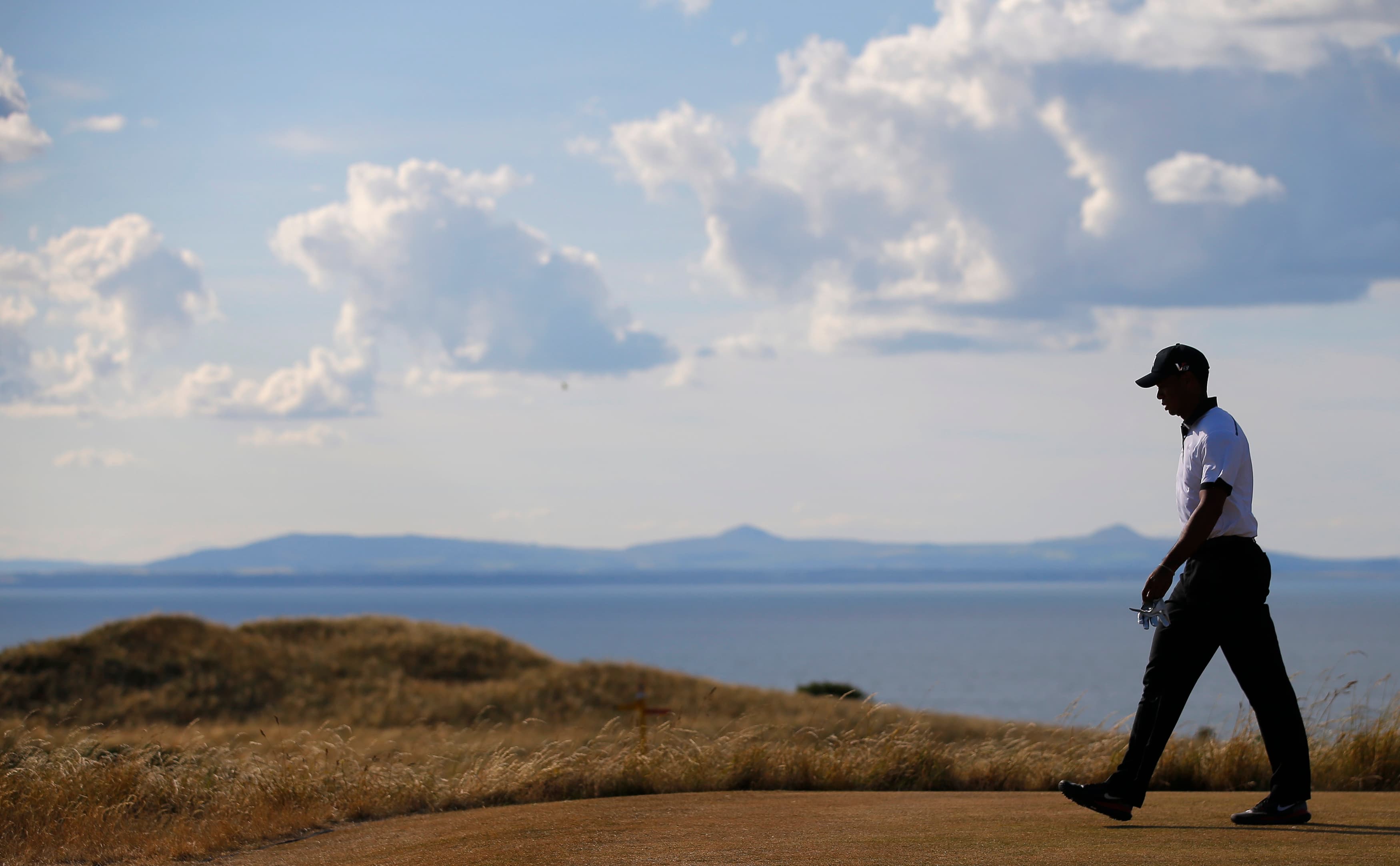 Tiger Woods walks off the 12th tee during the first round of the British Open golf Championship at Muirfield in Scotland July 18, 2013.