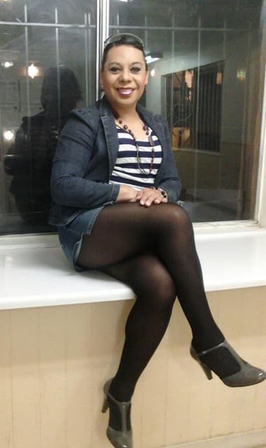 Gretta Soto Moreno sitting on a bench in front of a window