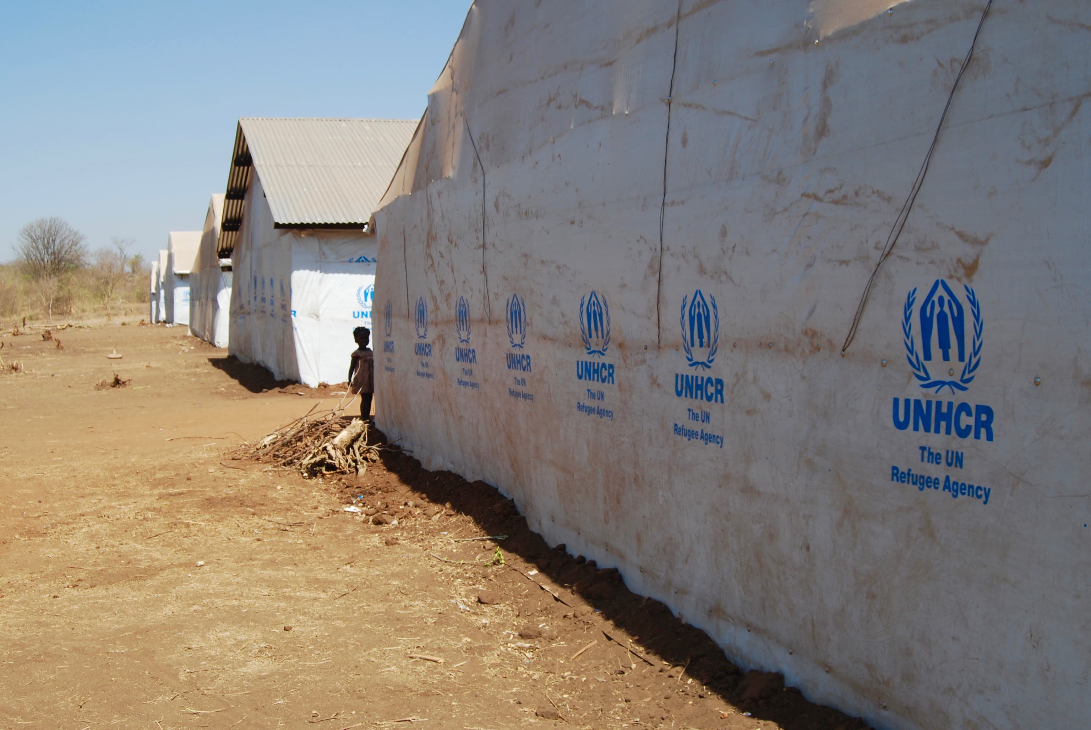 A young girl stands next to a row of tents at the newest refugee settlement in northern Uganda, called Palorinya.
