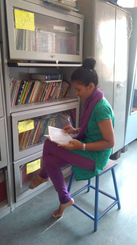 A young girl reads at a shelter for women who have survived sex trafficking.