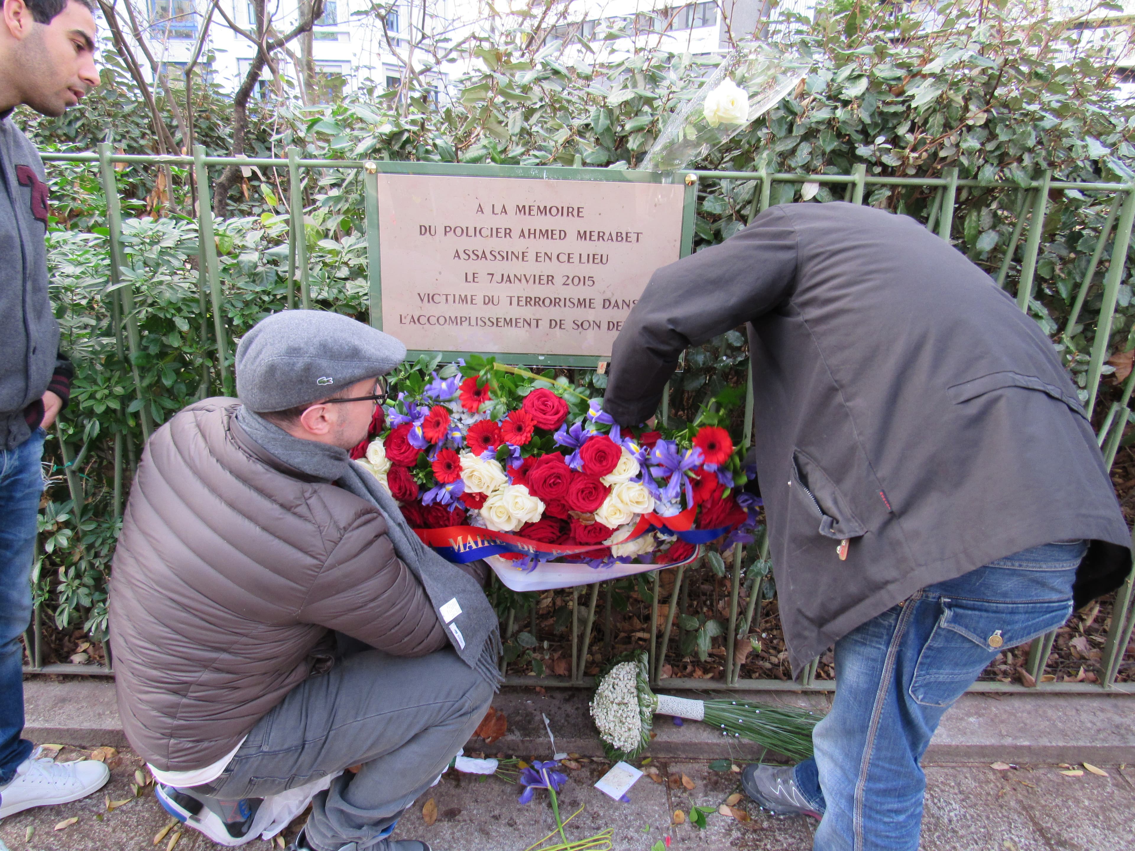 Some of the men in the neighborhood picked up the flowers laid in honor of Ahmed Merabet to protect them from foot traffic and dogs. Everyone in the community knew the local police officer.