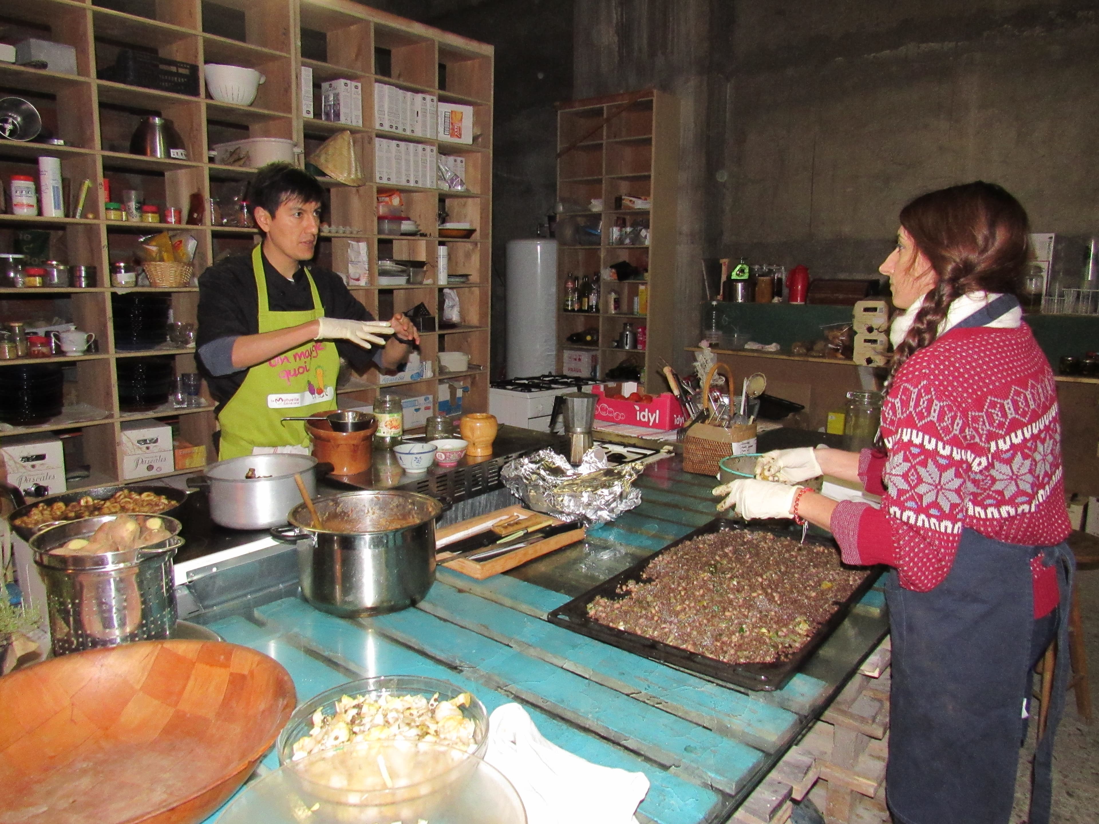 Freegan Pony guest Chef Santiago Rosero explains to a volunteer how to prepare a recent evening's dish of lentil risotto, with pickled and roasted vegetables.