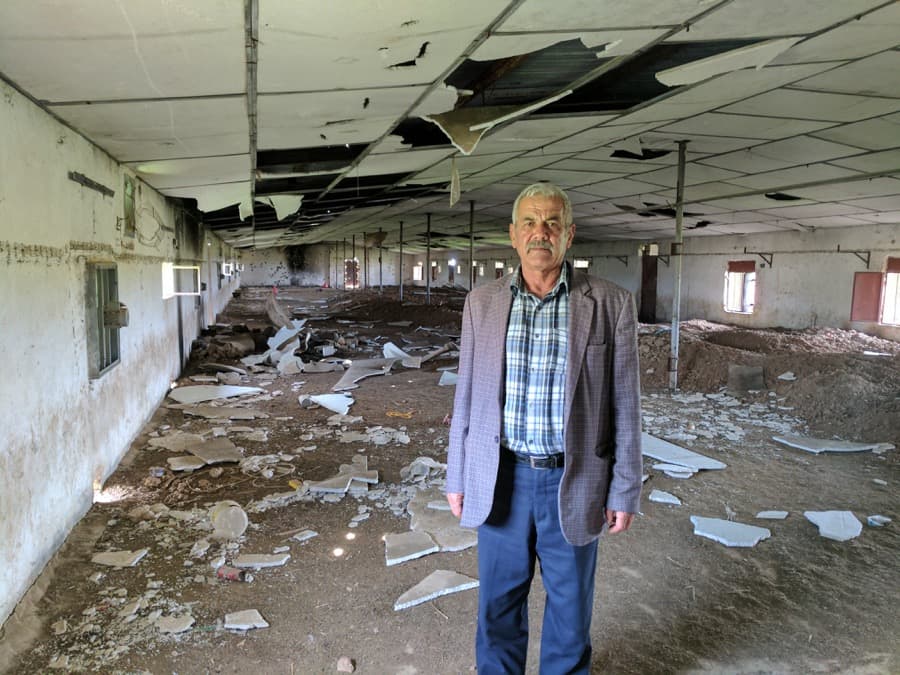 Hazm Aboush, 60, stands in his warehouse that used to house thousands of chickens