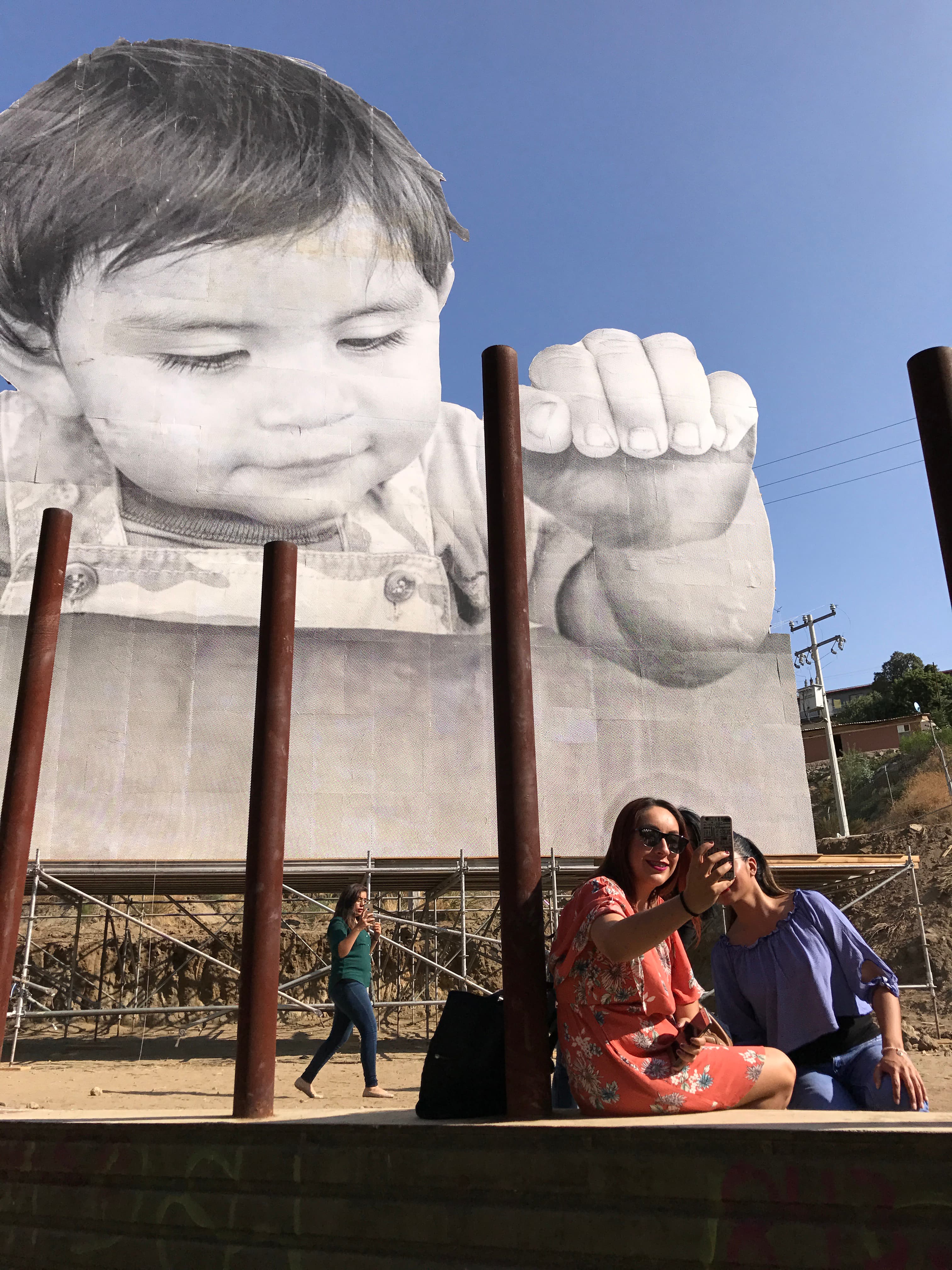 Woman in front of large print of baby take selfies