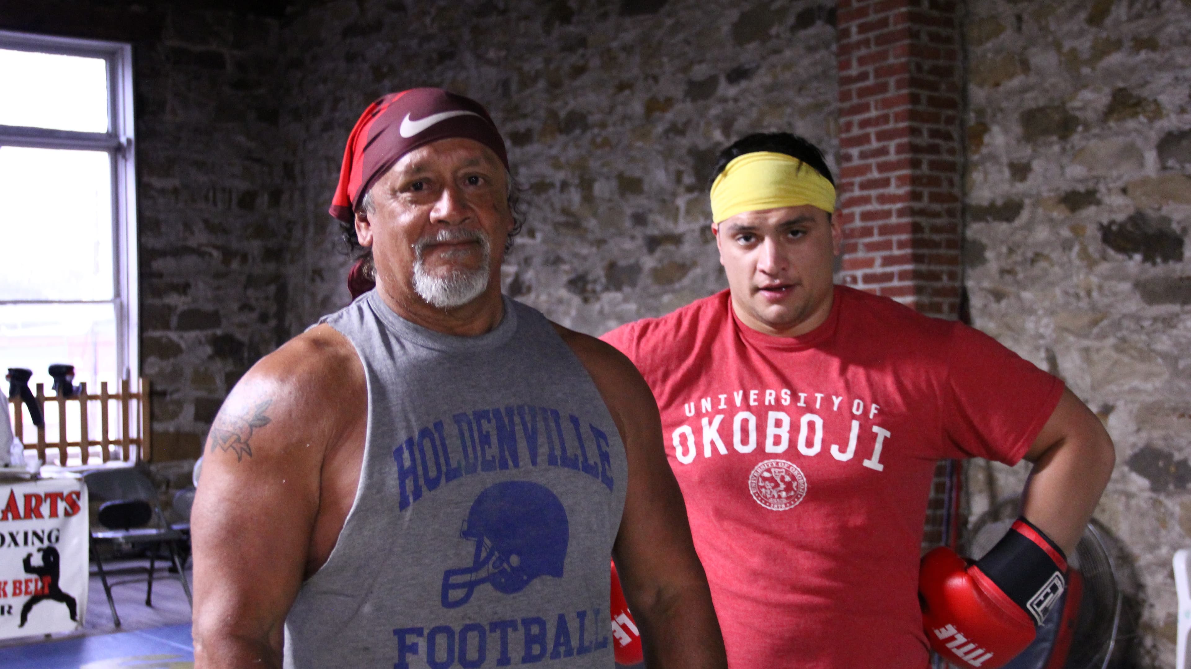 Two men stand in a boxing gym