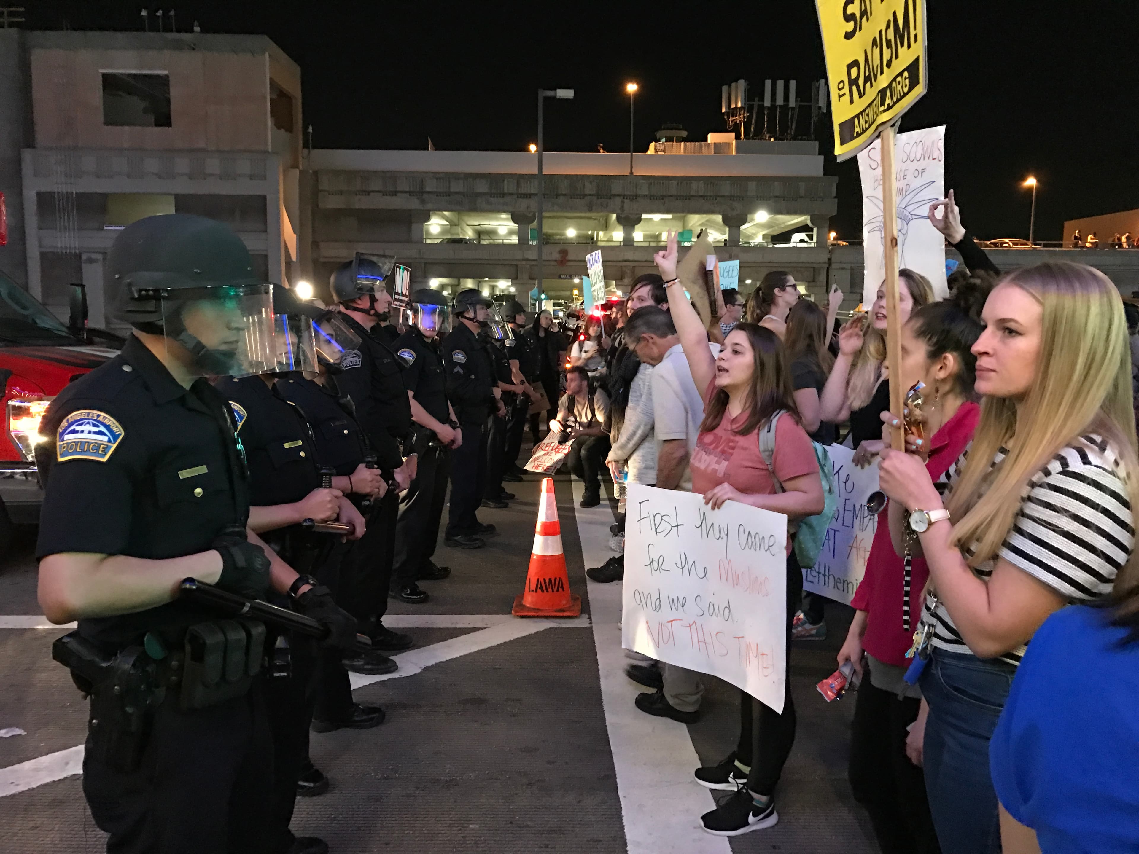 Police line up in front of protesters on sidewalk