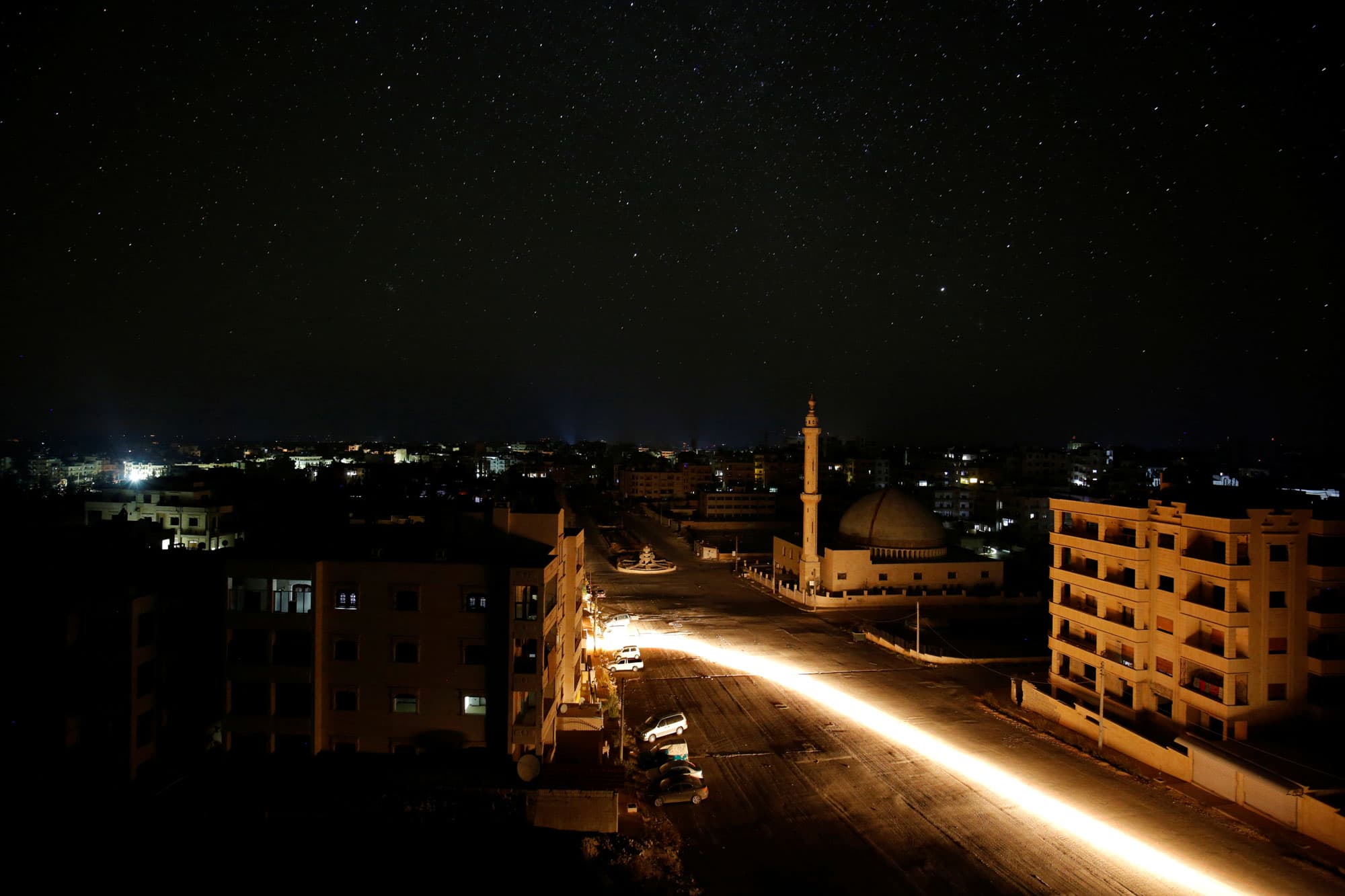 A vehicle drives past a mosque at night in Idlib, Syria.