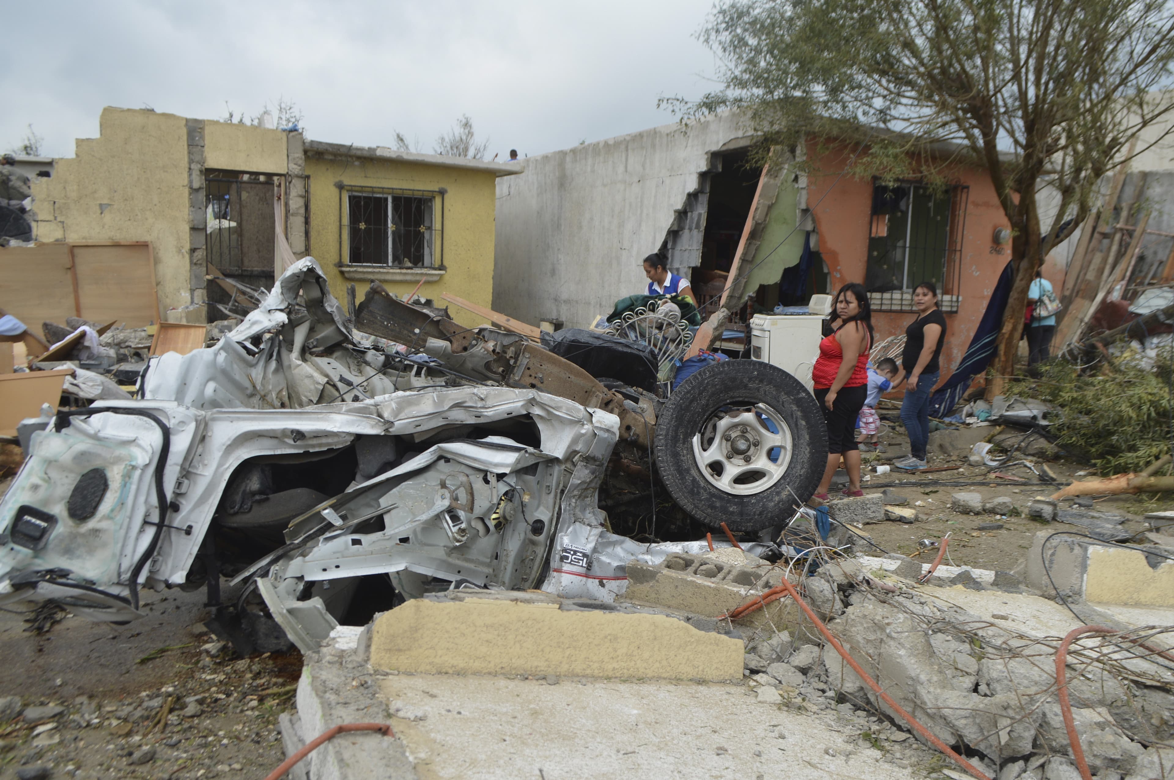 Residents stand outside their damaged houses after a tornado hit Ciudad Acuña. The whirlwind damaged as many as 350 homes, knocking down walls and ceilings, and slammed into vehicles in the city that lies across the Rio Grande from Del Rio, Texas.