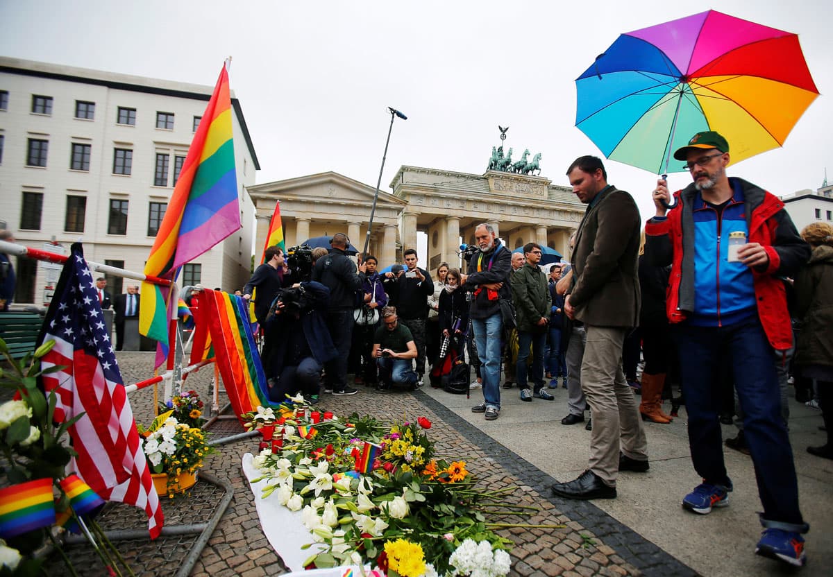 A man places a candle for the victims of the Orlando shooting in front of the US Embassy and Brandenburg Gate in Berlin, Germany.