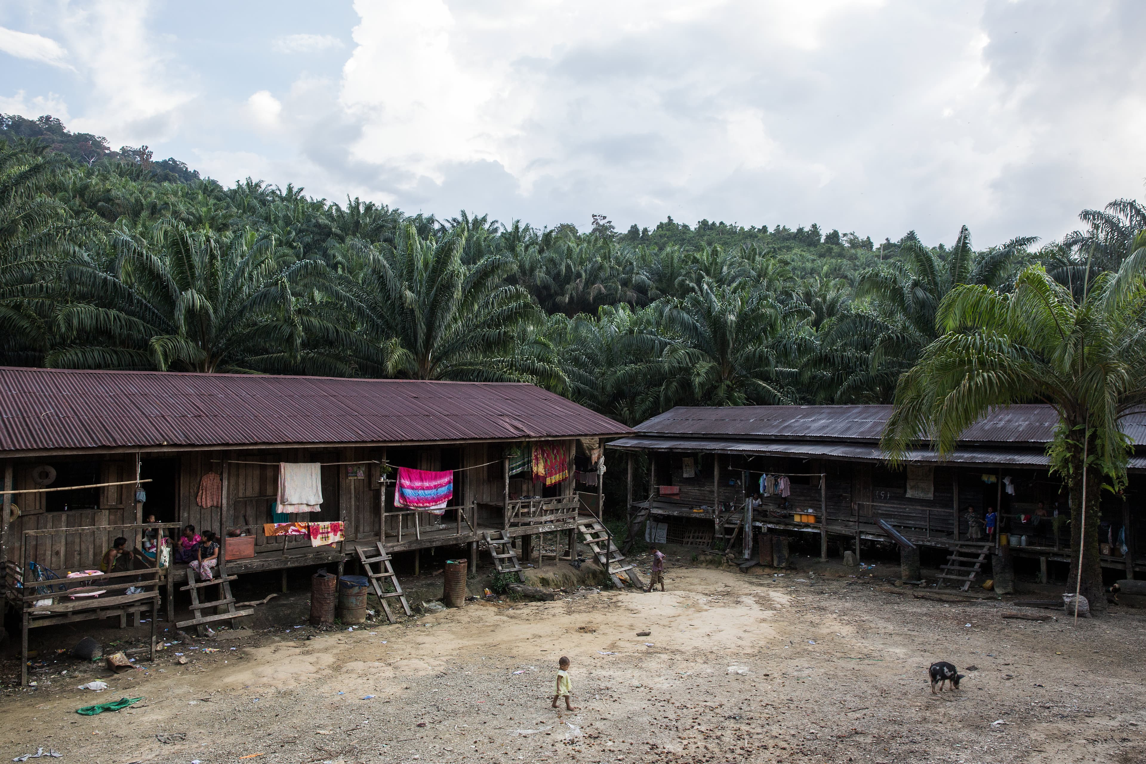 A child runs across a clearing at a small village where migrant workers for Supowin Palm Oil live outside Kawthaung, Myanmar, Nov. 14, 2016. Four families live in each row house, which are not equipped with basic amenities like electricity or running wate