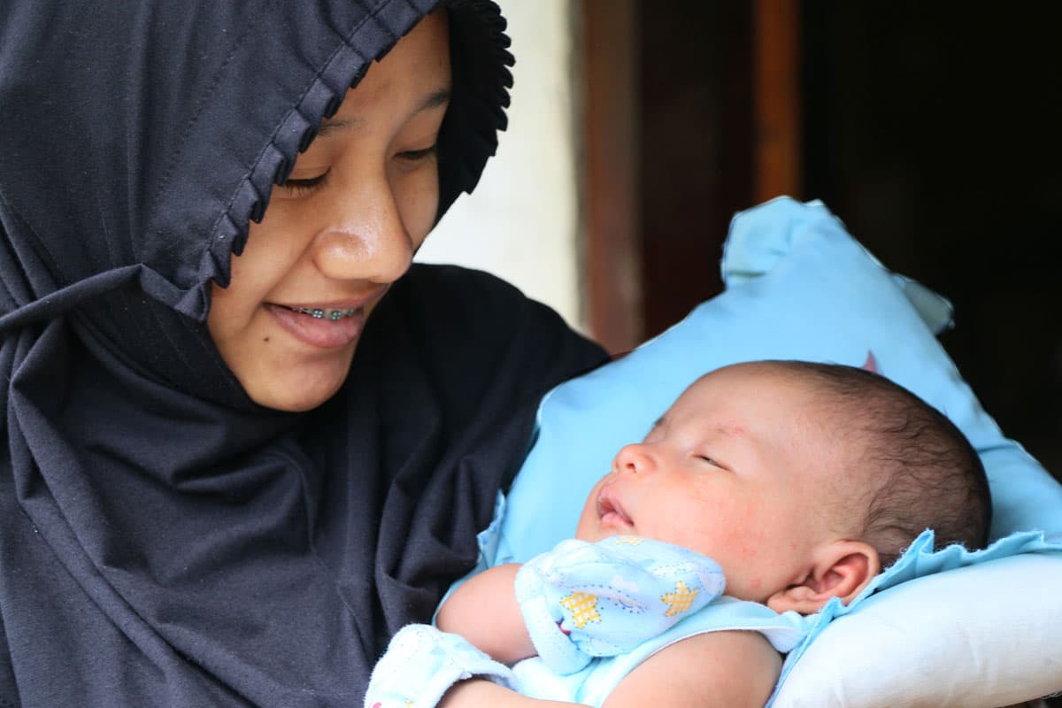 Wadianti, 19, holds her newborn baby, Arista.