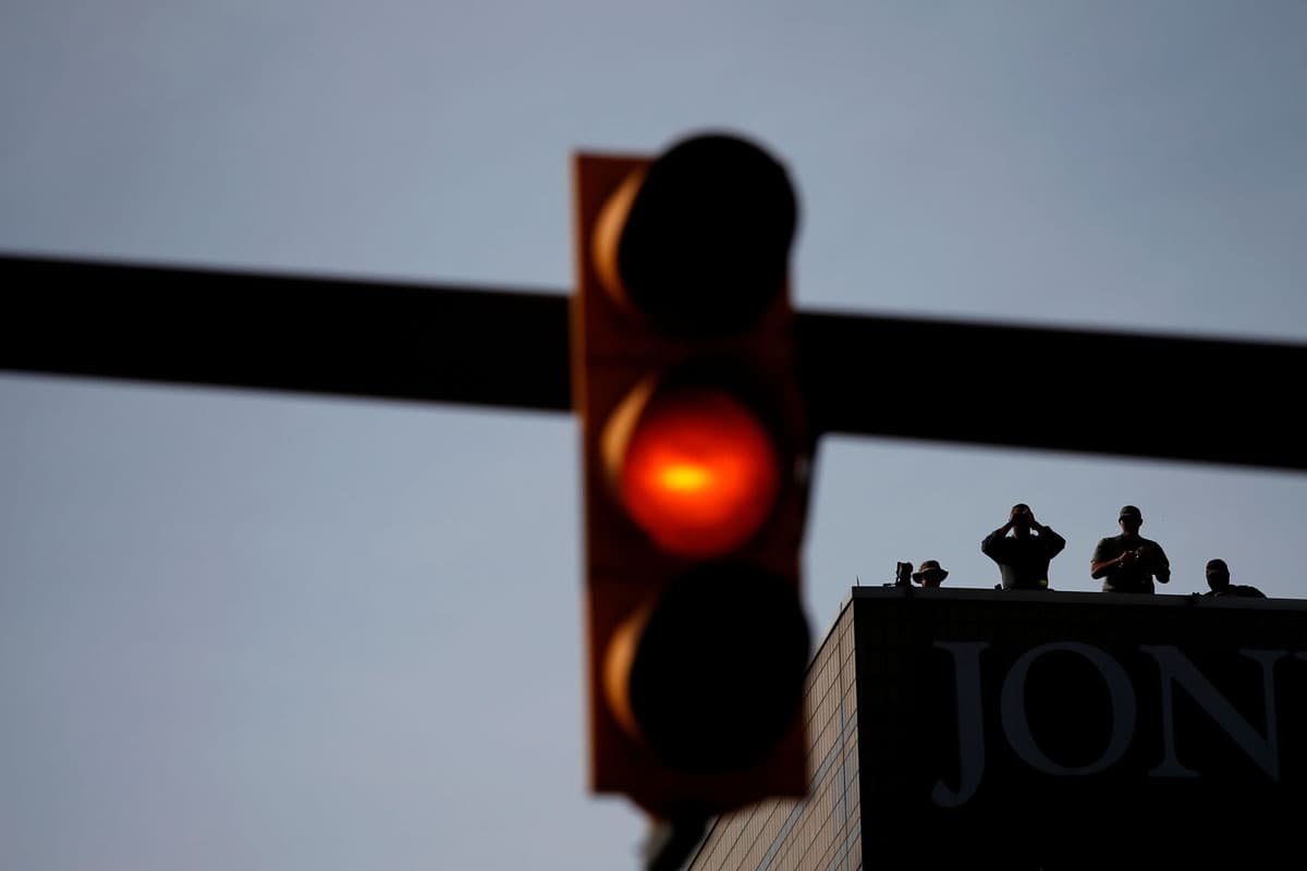 Security forces watch a protest march from the rooftop of a building near the RNC.