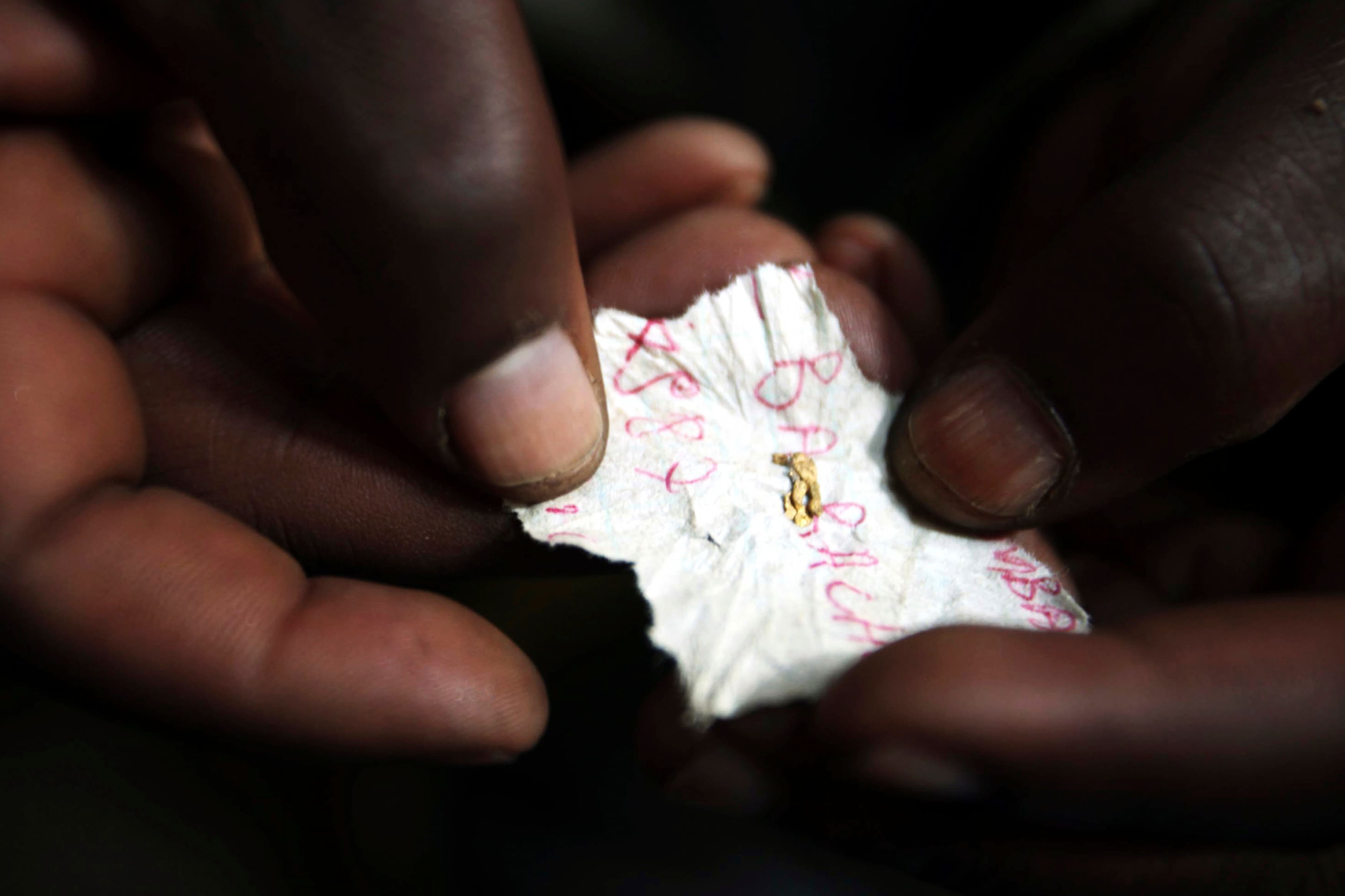 A Congolese mineral trader holds a piece of paper containing nuggets of gold in a mud hut at Numbi in eastern DRC, July 24, 2010.