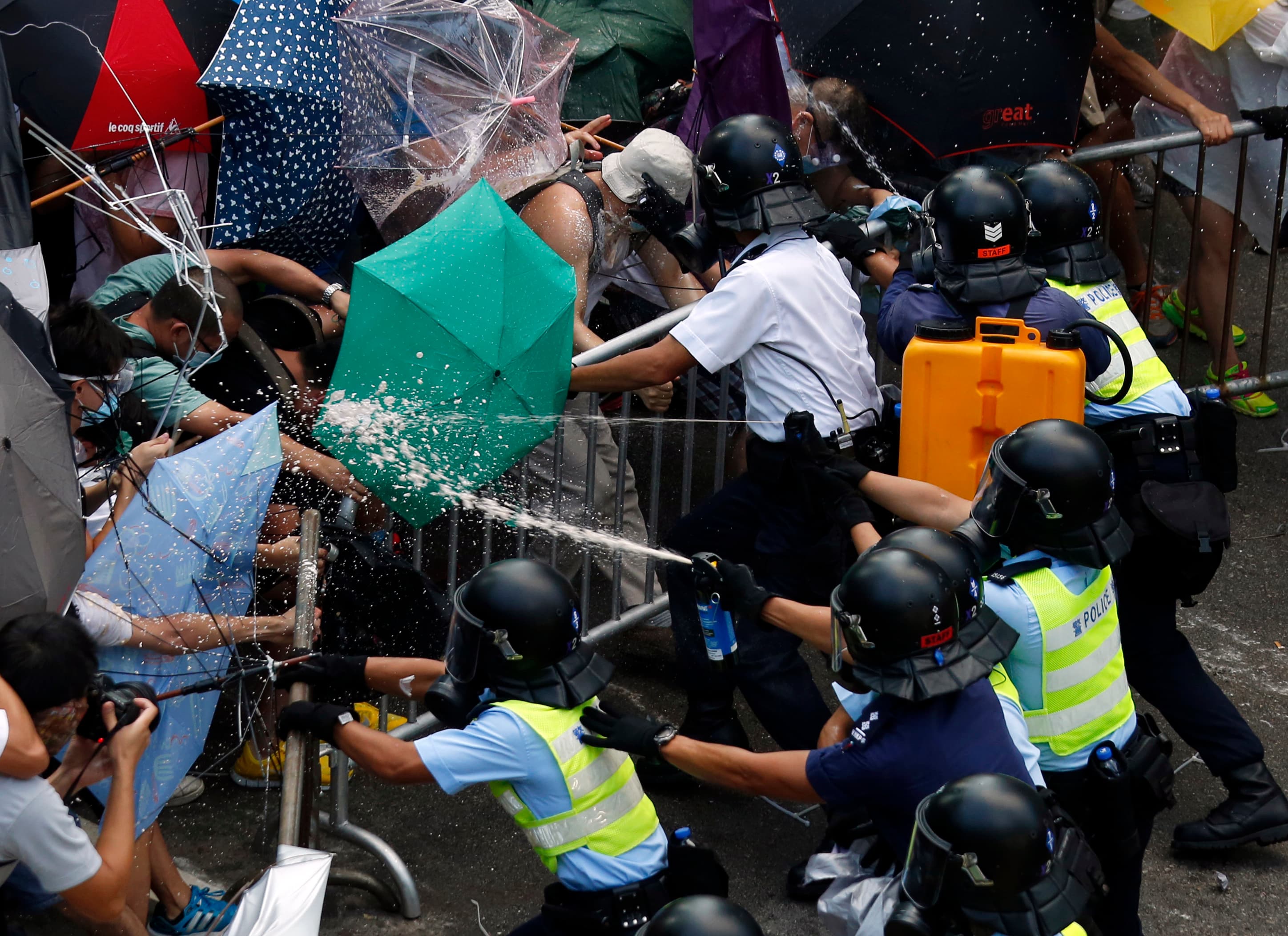 Police use pepper spray as they clash with protesters jamming the main street to the central financial district outside government headquarters in Hong Kong on September 28, 2014.