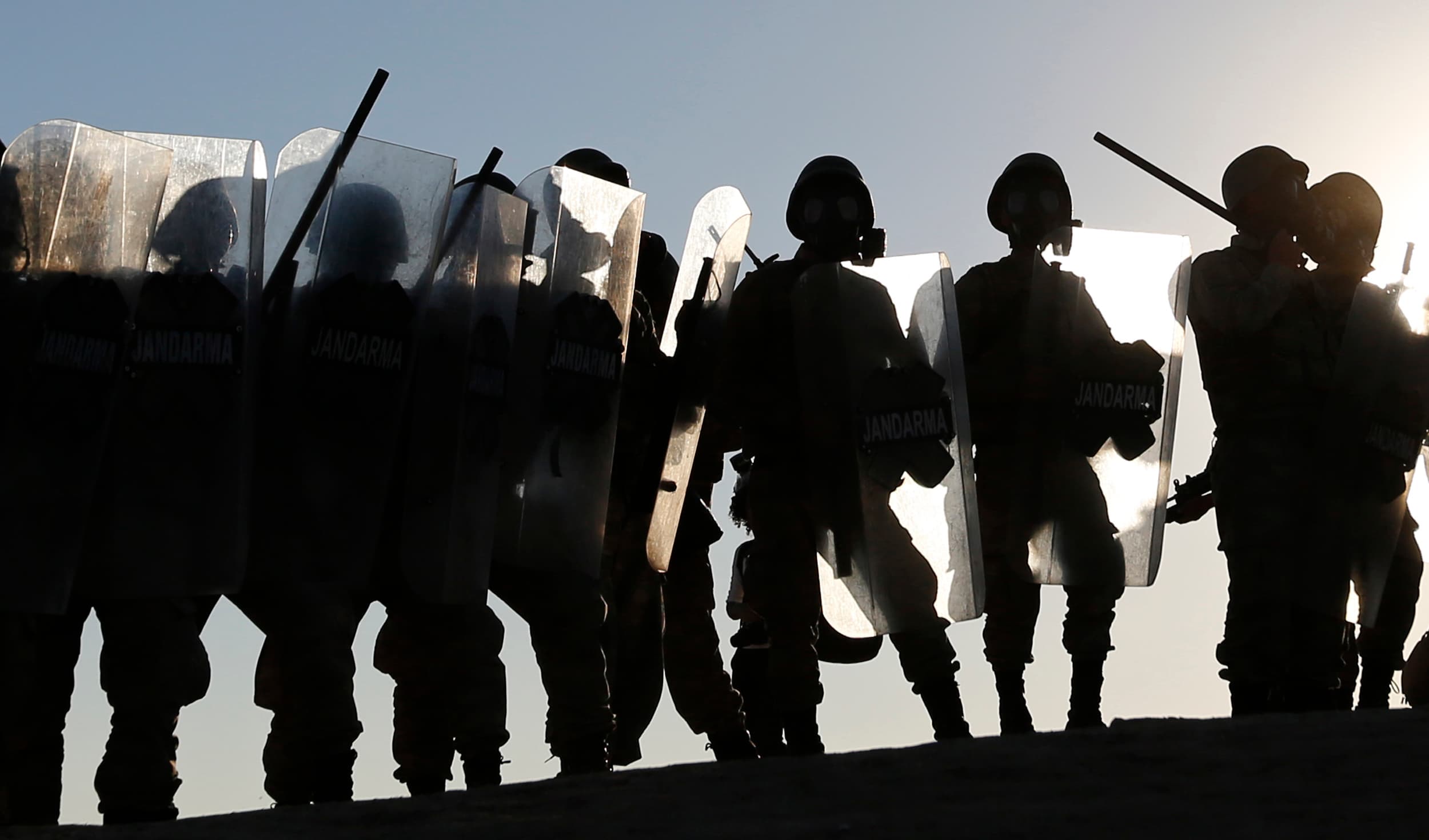 Turkish riot police prepare to face Kurdish protesters on the Turkey-Syria border.