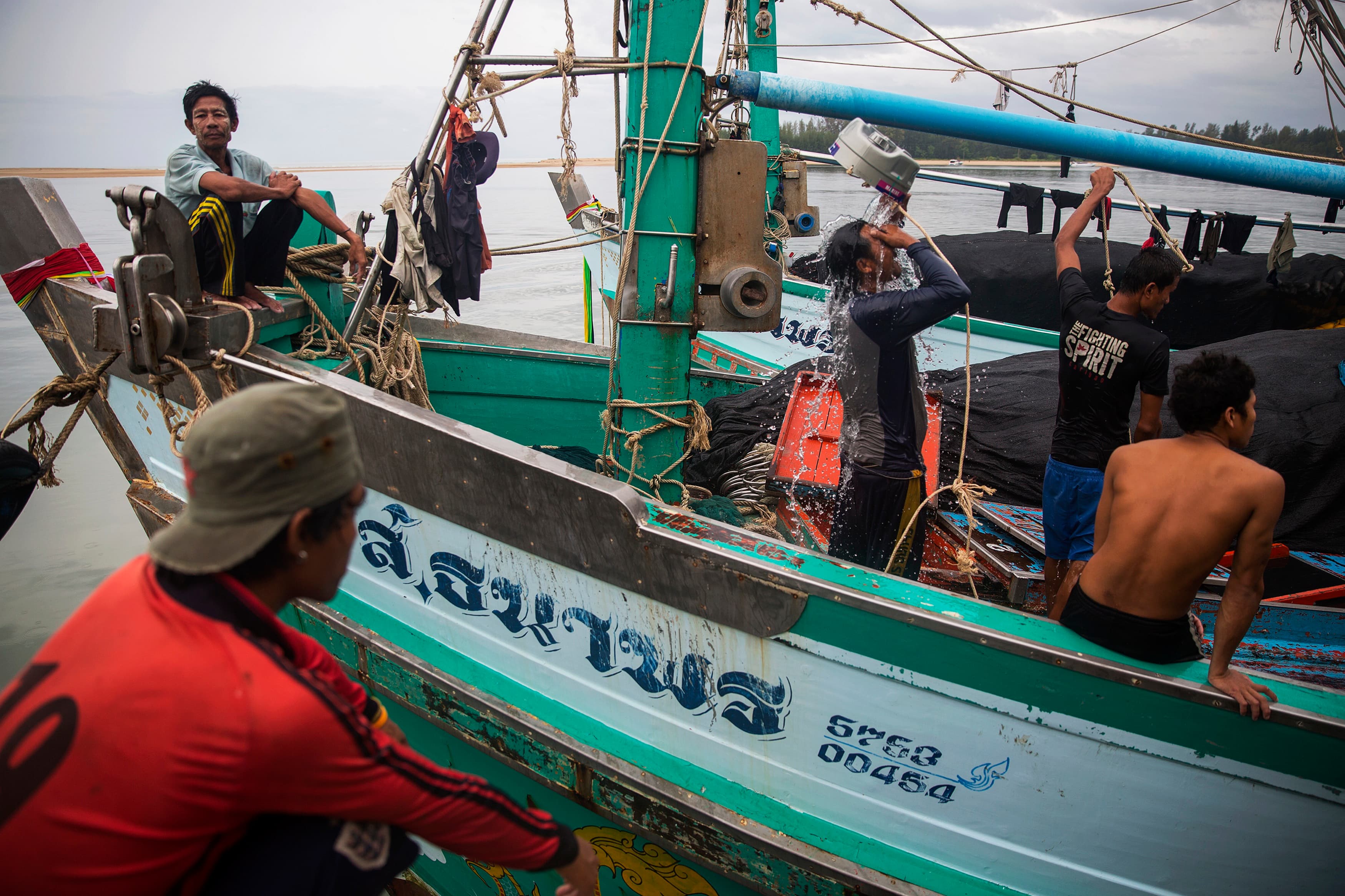 Migrant fishermen from Myanmar wash themselves after returning from the ocean to Ban Nam Khem, Thailand, Dec. 14, 2014.
