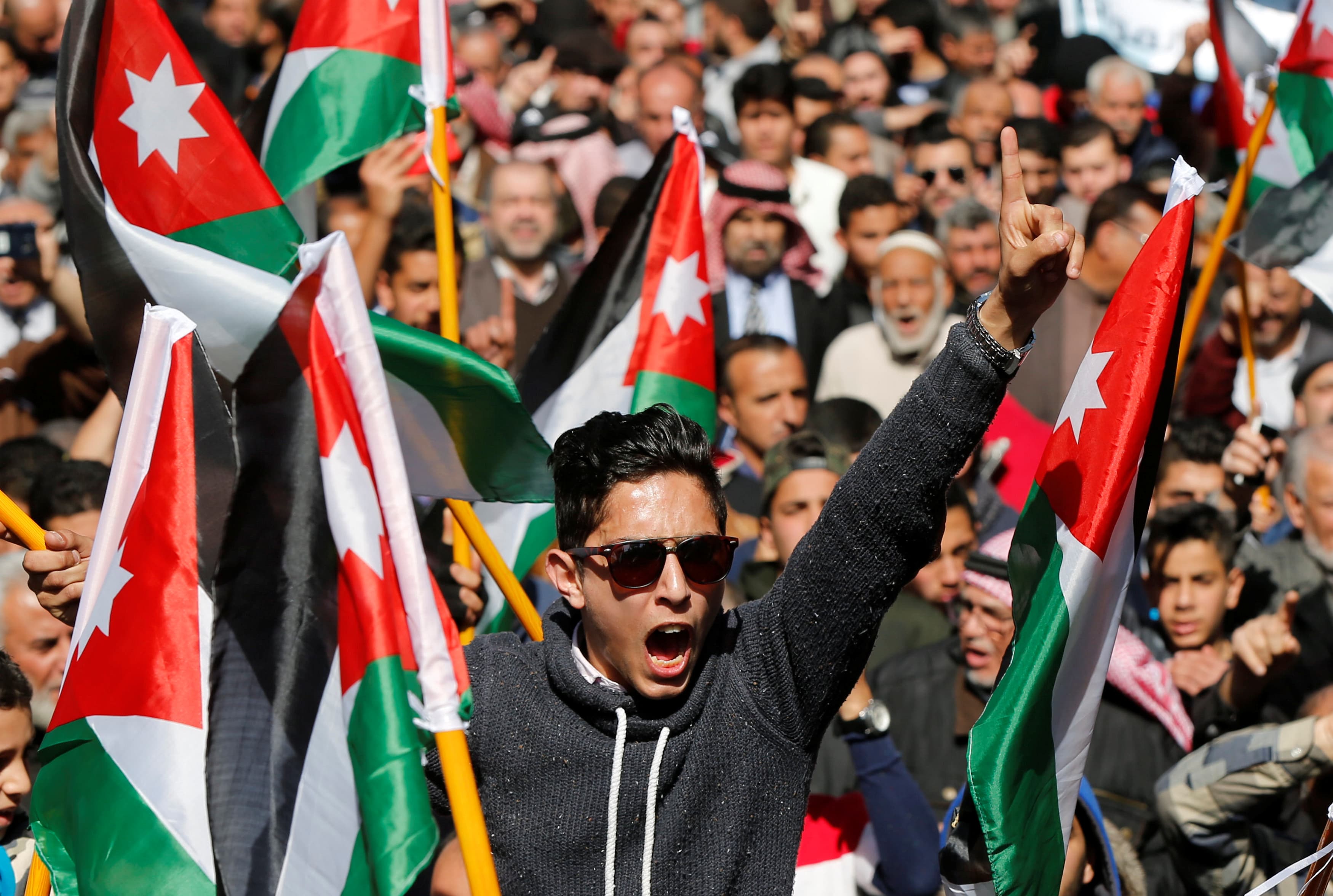 Demonstrators hold Jordanian national flags and chant slogans during a protest against rising prices and the imposition of more taxes, after the Friday prayer in Amman, Jordan, Feb. 24, 2017.