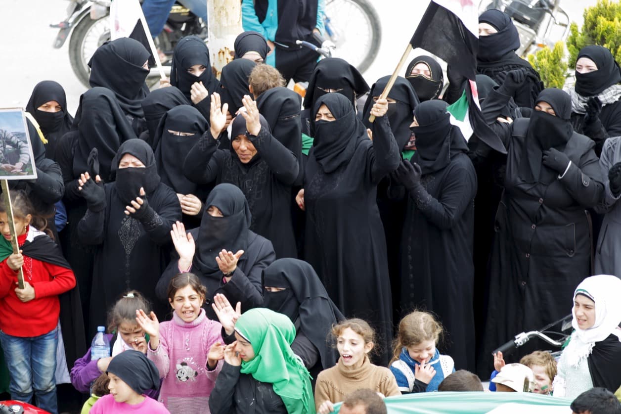 Protesters fully covered in traditional garb chant slogans during an anti-government protest in the rebel-controlled area of Maaret al-Numan town in Idlib province on March 25, 2016.