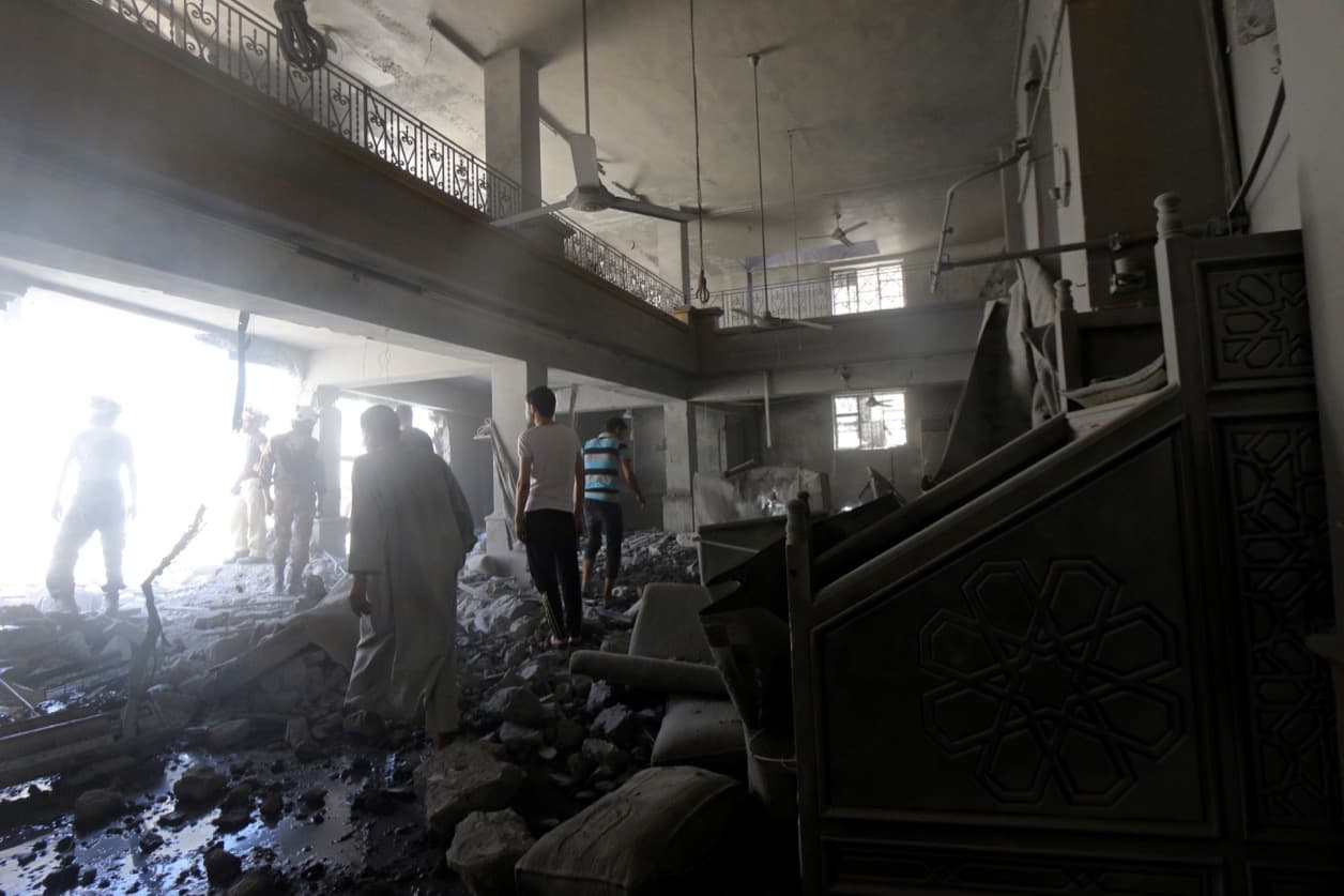 Civil defense members and residents inspect damage inside al-Aqsa mosque after an airstrike on the rebel held Al-Hilwaniyeh neighborhood in Aleppo on July 14.