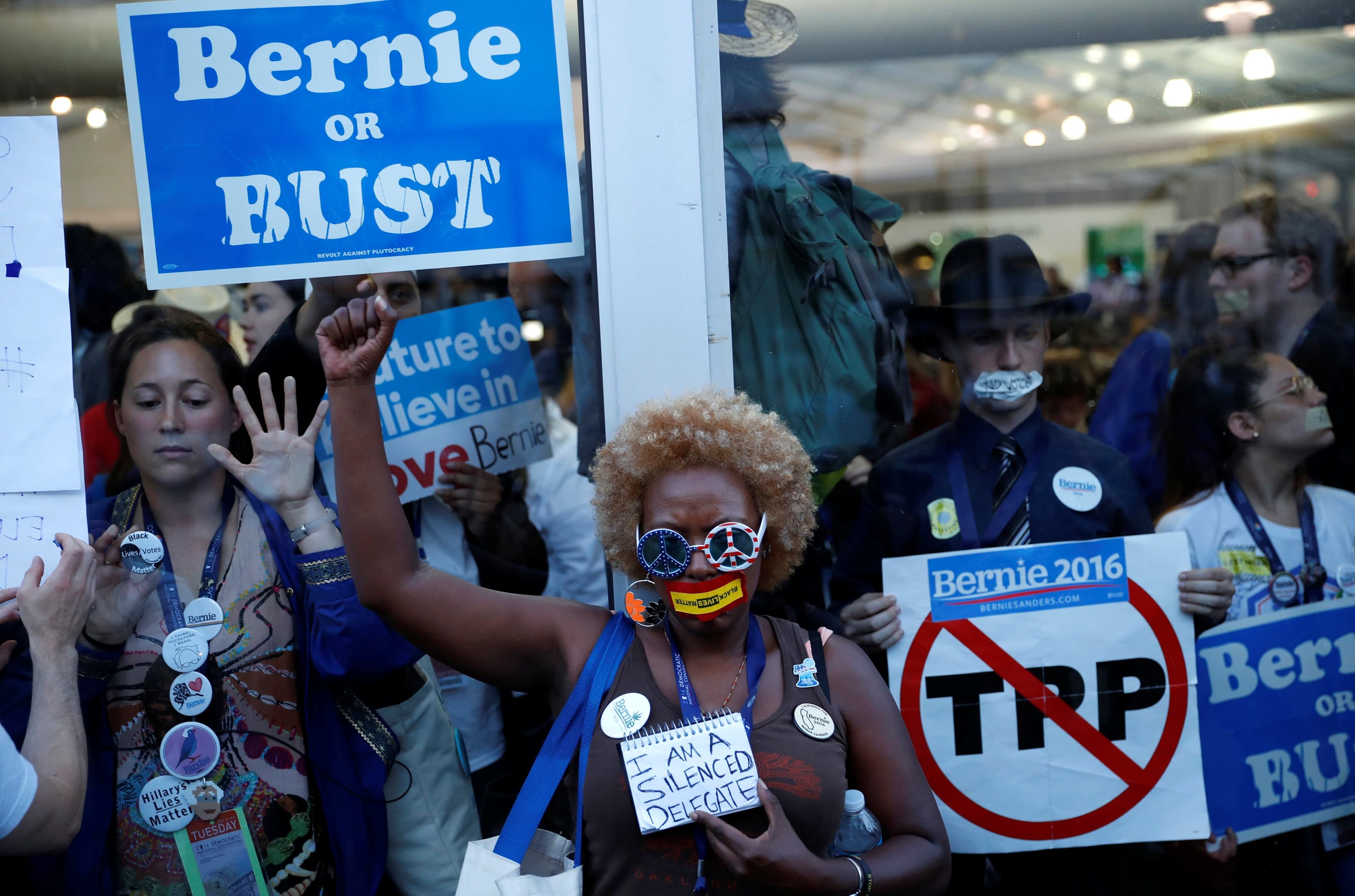 Supporters and delegates of Bernie Sanders protest from inside and outside the glass of the convention arena after they stormed off the convention floor when Hillary Clinton won the nomination.