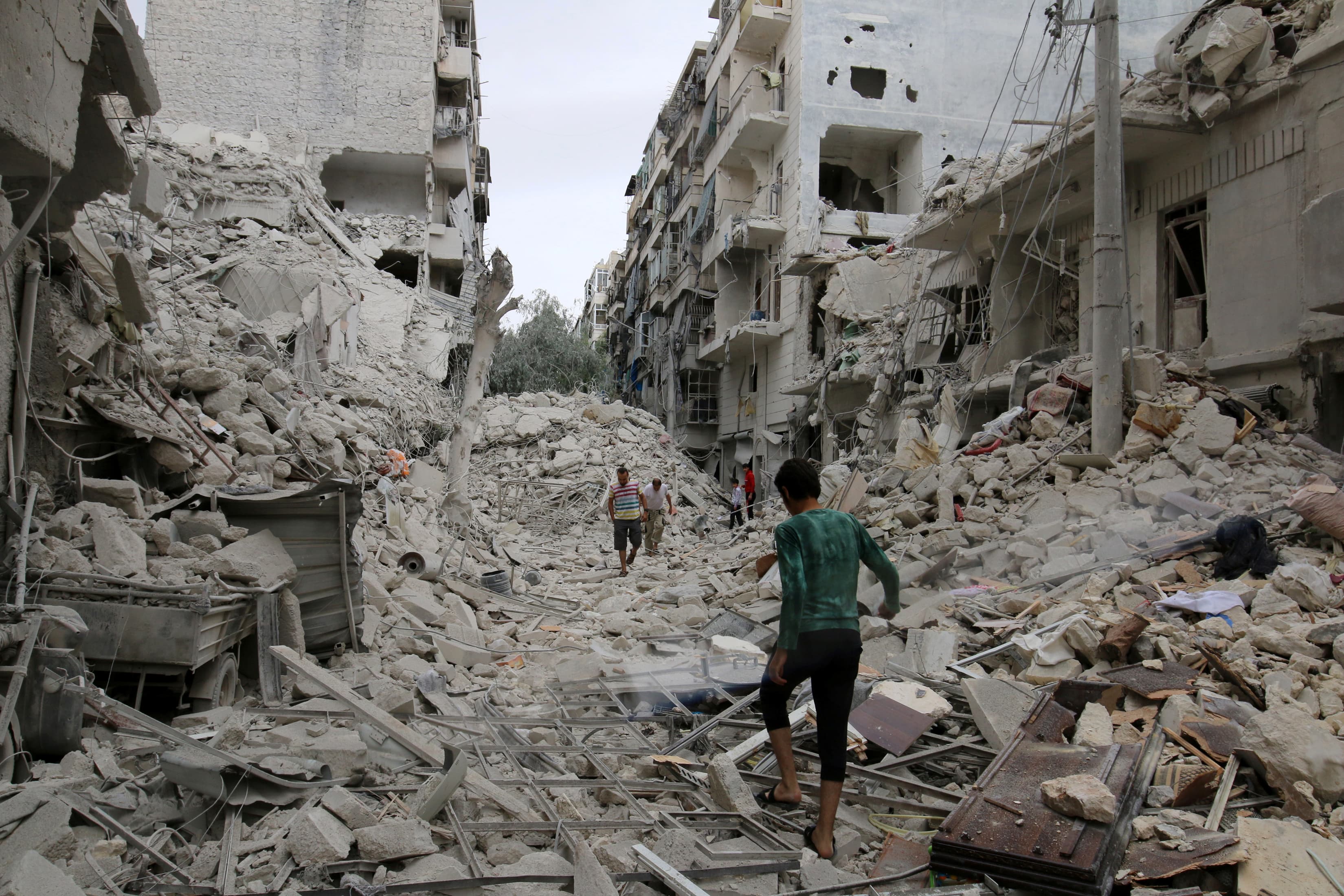 People inspect a damaged site after airstrikes on the rebel held Tariq al-Bab neighborhood of Aleppo, Syria September 23, 2016.