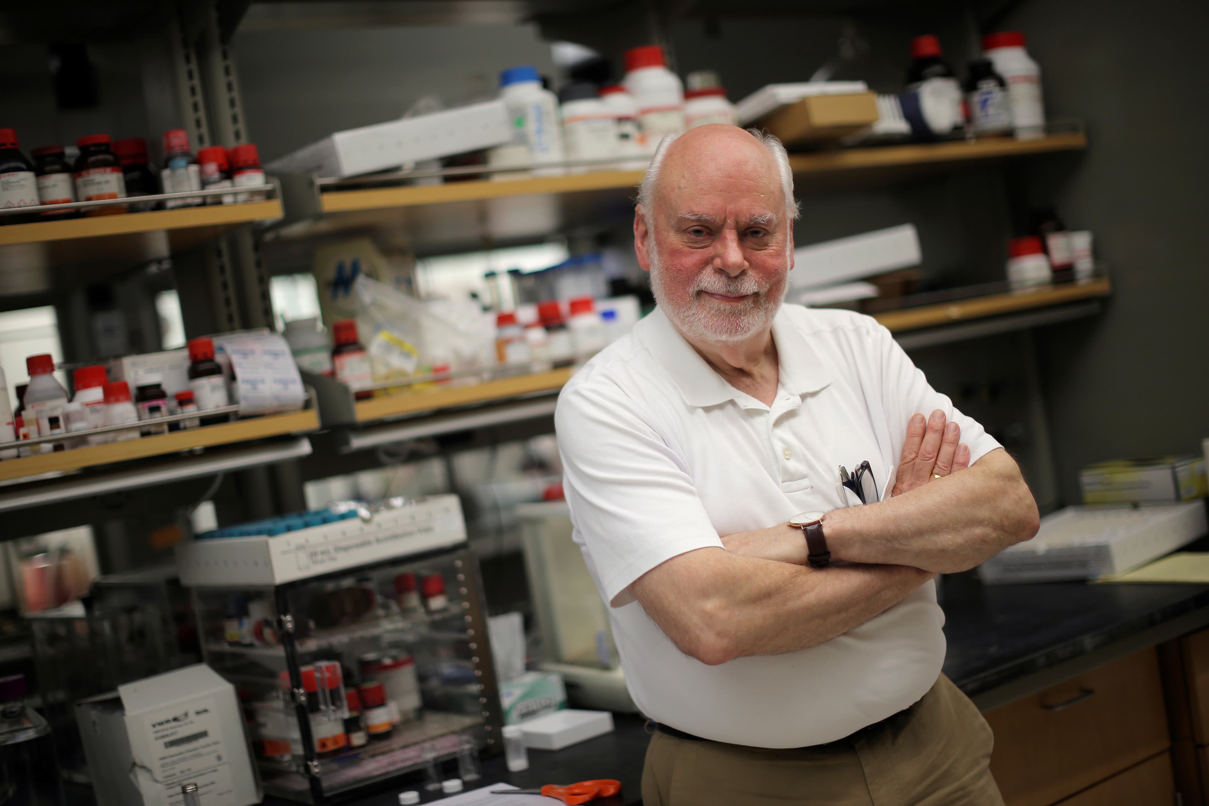 Man standing with arms folded in front of laboratory
