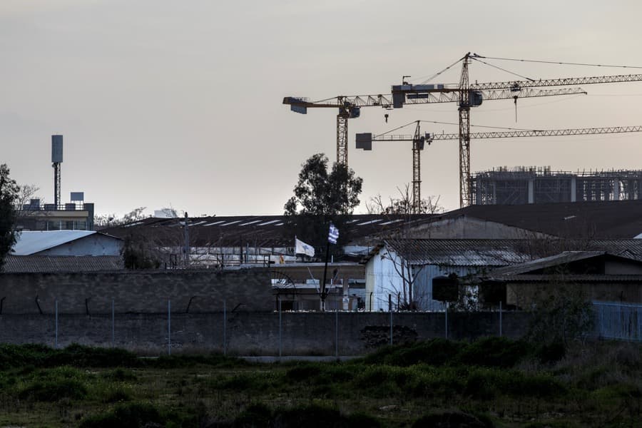 A Greek national flag waves on the wall of an old naval base where the construction of the first formal mosque is underway, in Athens