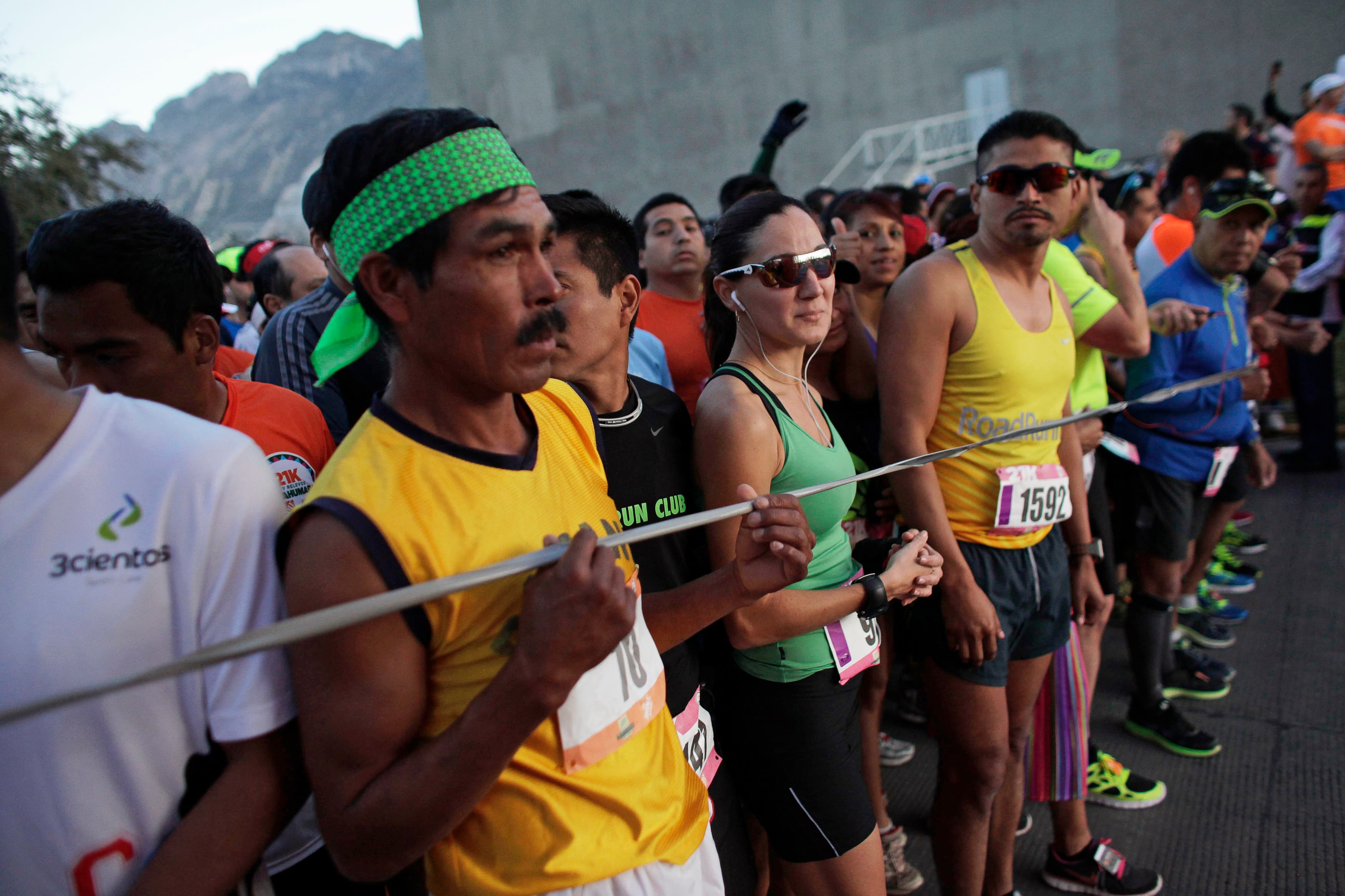 A Tarahumara man (front L) prepares next to other athletes before competing in a 21 km (13 miles) marathon in San Pedro Garza Garcia, on the outskirts of Monterrey, February 16, 2014.